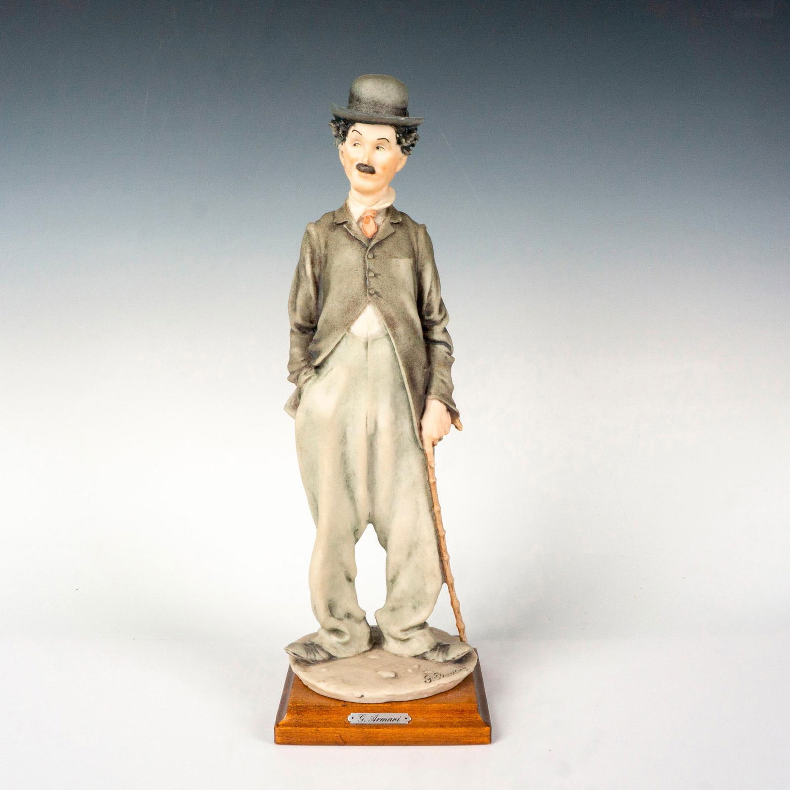 Florence Giuseppe Armani Figurine, Charlie Chaplin: This figurine features the renowned Charlie Chaplin standing on a square wooden base. Figurine 3219. Giuseppe Armani golden plate on wooden base. Giuseppe Armani is signed to base. This item has its o