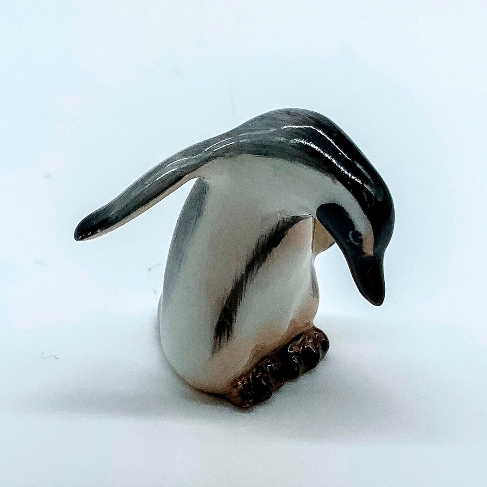 Penguin K24 - Royal Doulton Animal Figure: Bone China penguin with one raised wing hand painted with glossy grey, white and black coloration; Royal Doulton Backstamp. Artist: Peggy Davies Issued: 1940-1968 Dimensions: 1.5"L x 1.5"W x 1.5"H Man