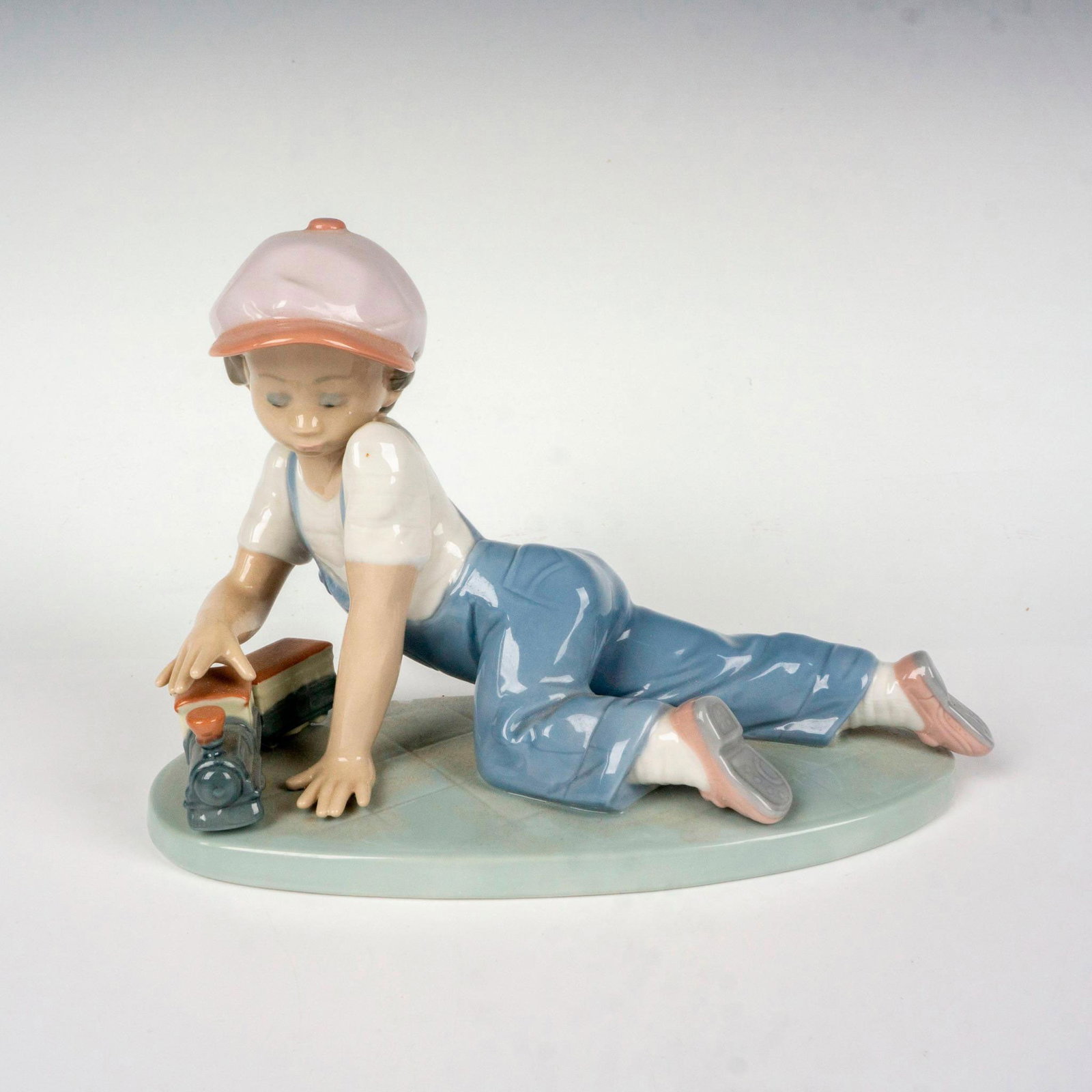 All Aboard 1007619 - Lladro Porcelain Figurine: Glossy finish; Lladro backstamp. Includes original box. Box measures: 10"L x 9.5"W x 6.5"H. Artist: Antonio Ramos Issued: 1992 - 1995 Dimensions: 5"H x 7.5"W Manufacturer: Lladro Country of Origin: