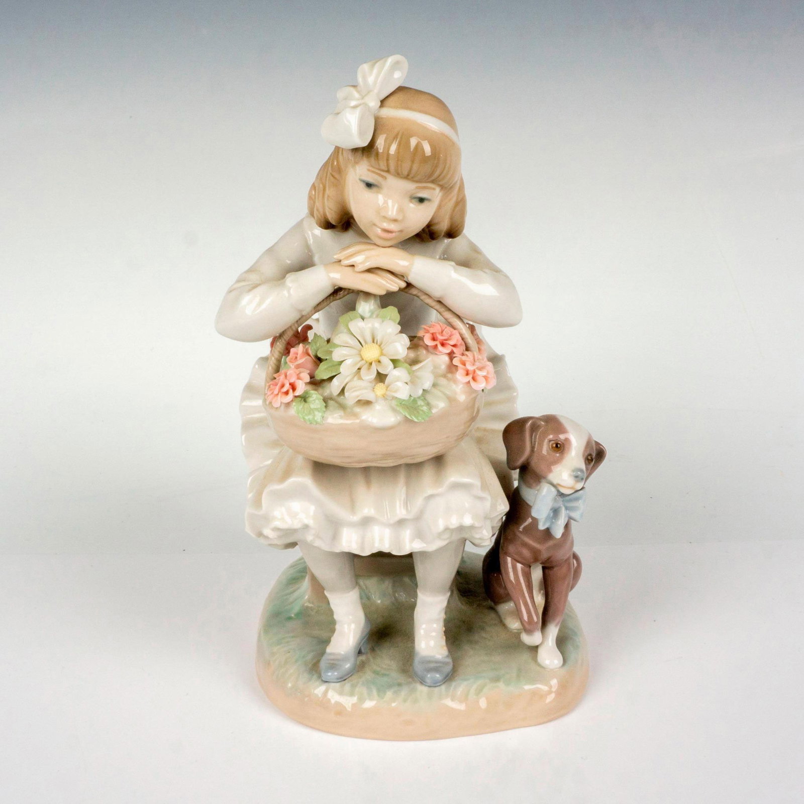 Girl With Flowers 1001088 - Lladro Porcelain Figurine: Glossy finish; Lladro backstamp. Artist: Antonio Ballester Issued: 1969 - 1989 Dimensions: 8.25"H Manufacturer: Lladro Country of Origin: Spain
