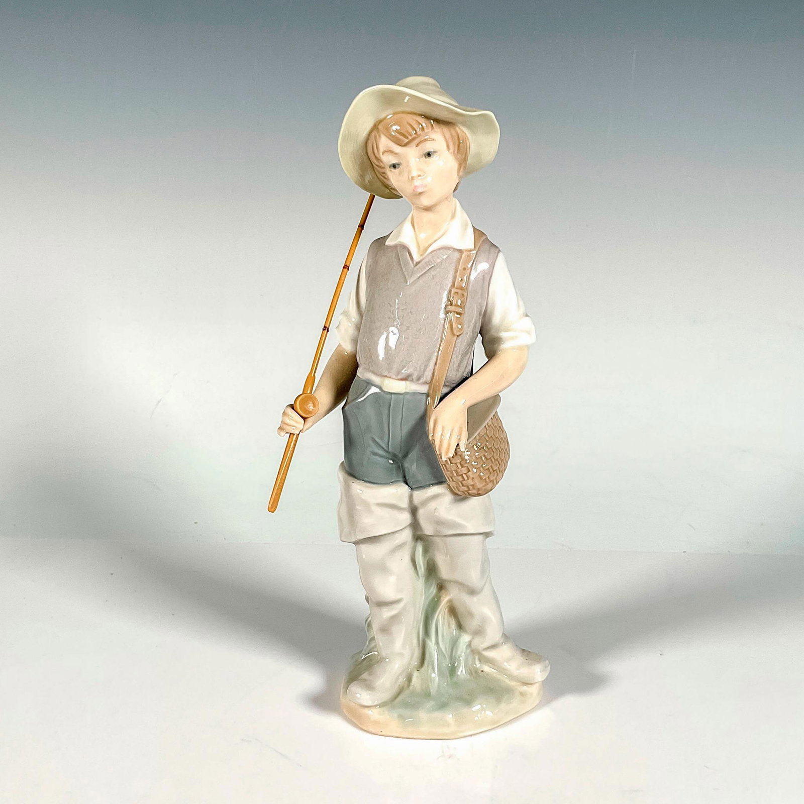 Going Fishing 1004809 - Lladro Porcelain Figurine: Glossy finish; Lladro backstamp. Includes original box. Box measures: 10"L x 5"W x 4.75"H. Artist: Salvador Furio Issued: 1972 - 2001 Dimensions: 8.5"H x 3.25"W Manufacturer: Lladro Country of Origin: