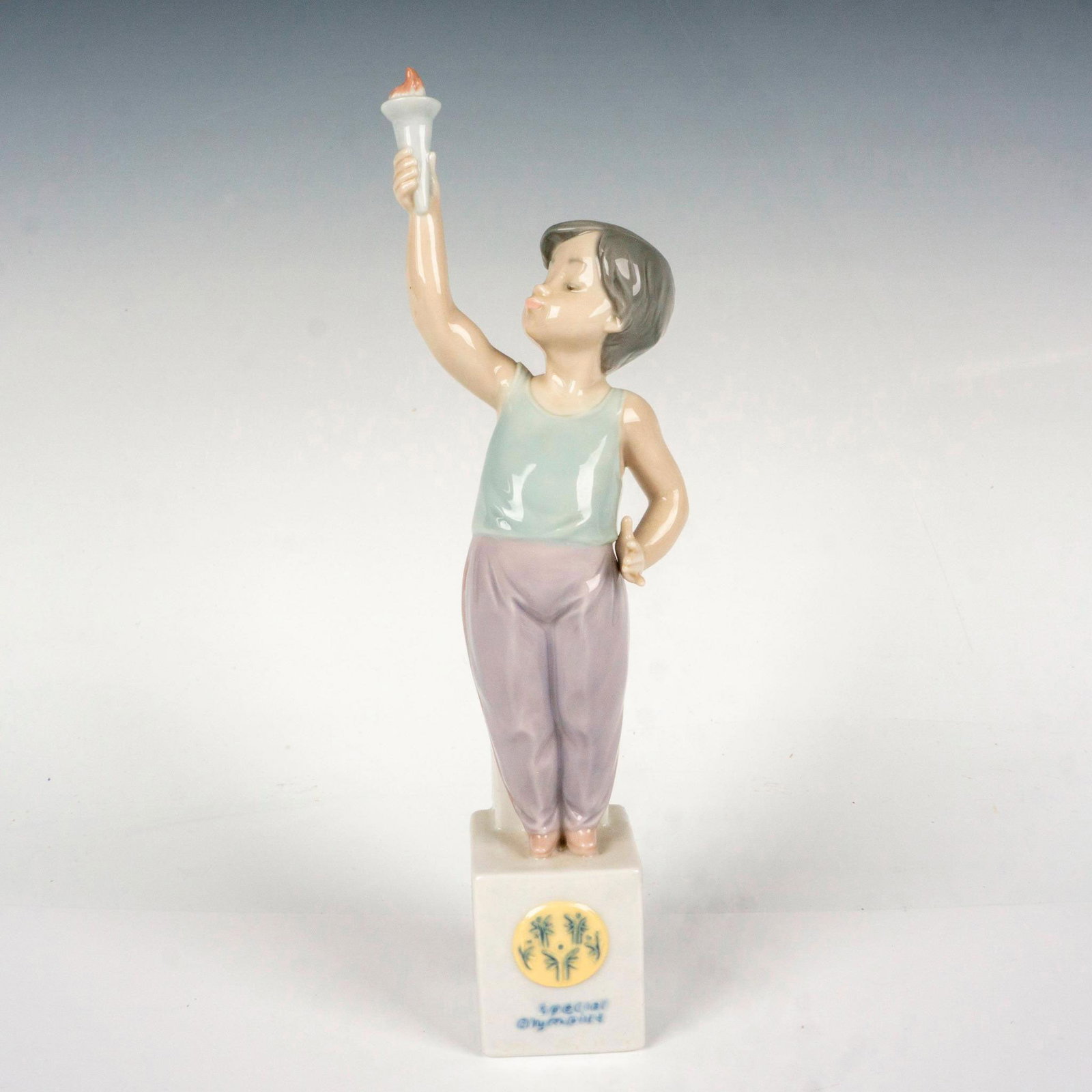 Special Torch 1007513 - Lladro Porcelain Figurine: Glossy finish; Lladro backstamp. Includes original box. Box measures: 14"L x 4.75"W x 4.75"H. Artist: Antonio Ramos Issued: 1992 - 1996 Dimensions: 10"H Manufacturer: Lladro Country of Origin: Spa