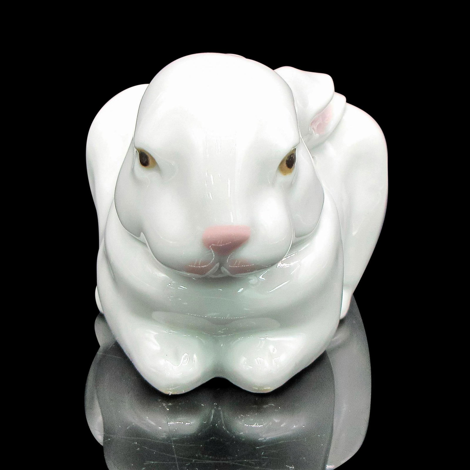 Sleeping Bunny 1005904 - Lladro Porcelain Figurine: Glazed white figurine with accents of pink on ears and nose. Amber and black eyes. Lladro backstamp. Artist: Fulgencio Garcia Issued: 1992 Dimensions: 5"L x 3"W x 2.5"H Manufacturer: Lladro Country o
