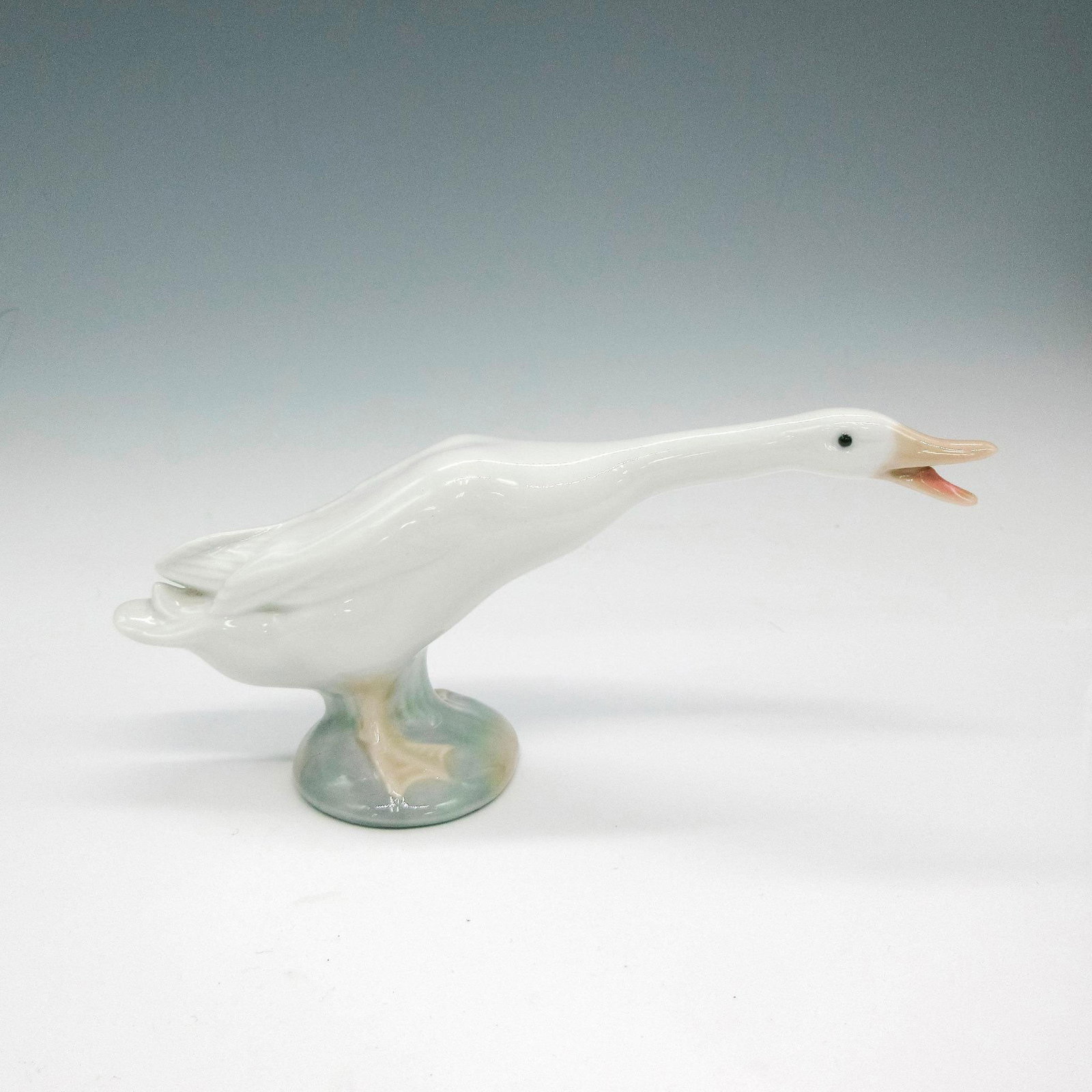 Little Duck 1004551 - Lladro Porcelain Figurine: Glazed figural honking colored in soft white with tan accents. Lladro backstamp. Artist: Fulgencio Garcia Issued: 1969 - 2001 Dimensions: 6.25"L x 2.25"W x 3"H Manufacturer: Lladro Country of Origin: