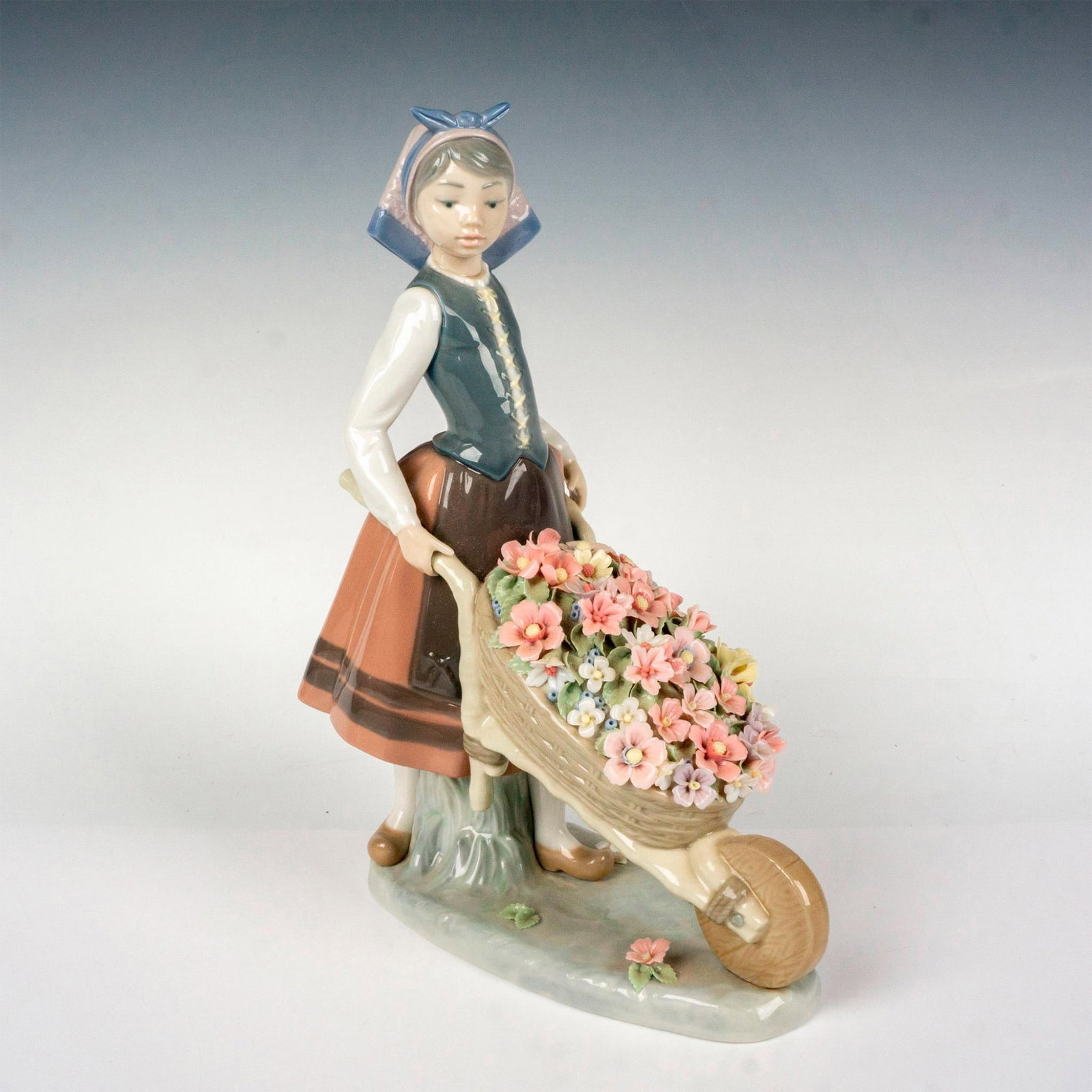 A Barrow Of Blossoms 1001419 - Lladro Porcelain Figurine: Glossy finish; Lladro backstamp. Includes original box. Box measures: 10.5"L x 12.5"W x 6"H. Artist: Francisco Catala Issued: 1982 - 2004 Dimensions: 10.5"H x 7.25"W Manufacturer: Lladro Country of Or