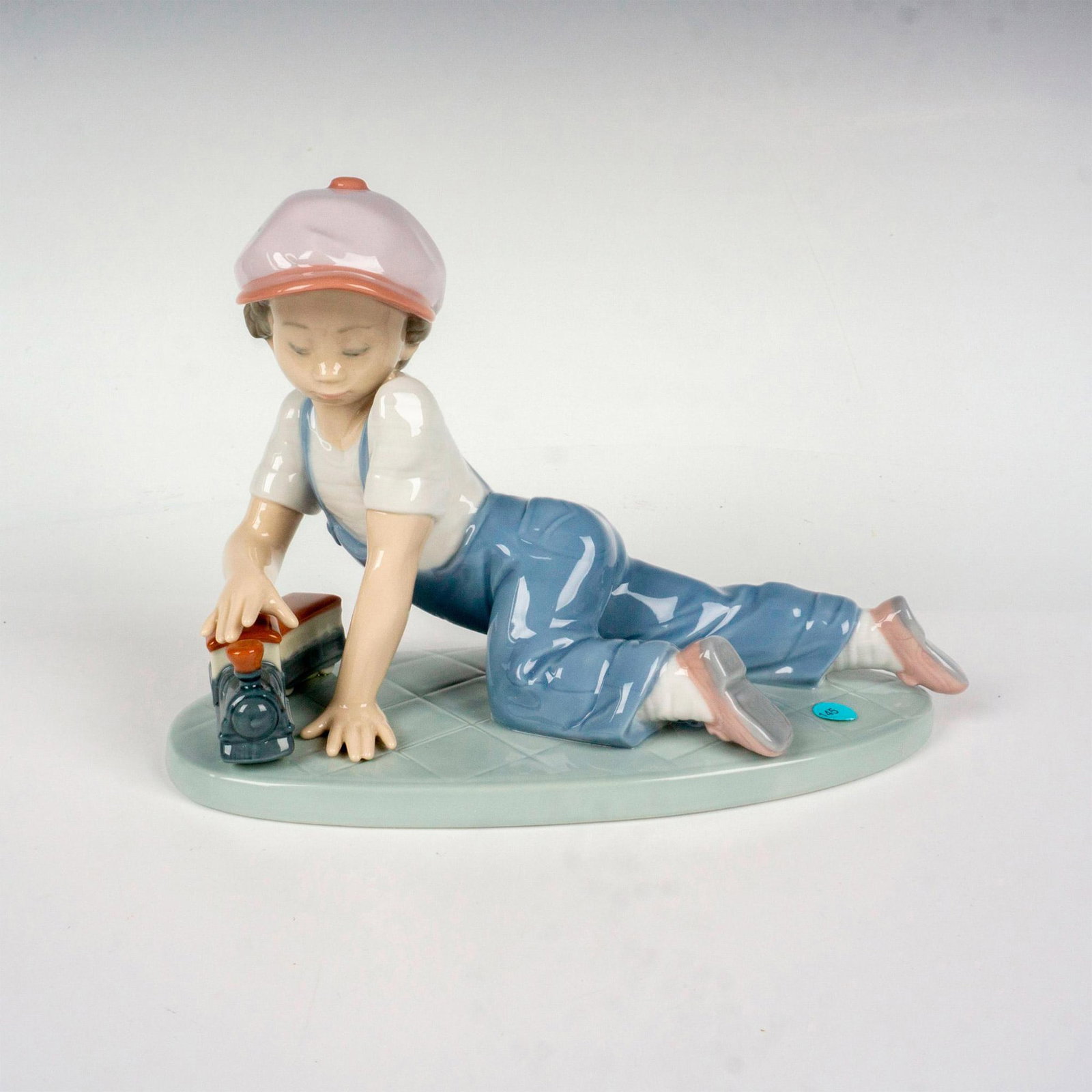 All Aboard 1007619 - Lladro Porcelain Figurine: Glossy finish; Lladro backstamp. Includes original box. Box measures: 10"L x 9.5"W x 6.5"H. Artist: Antonio Ramos Issued: 1992 - 1995 Dimensions: 5"H x 7.5"W Manufacturer: Lladro Country of Origin: