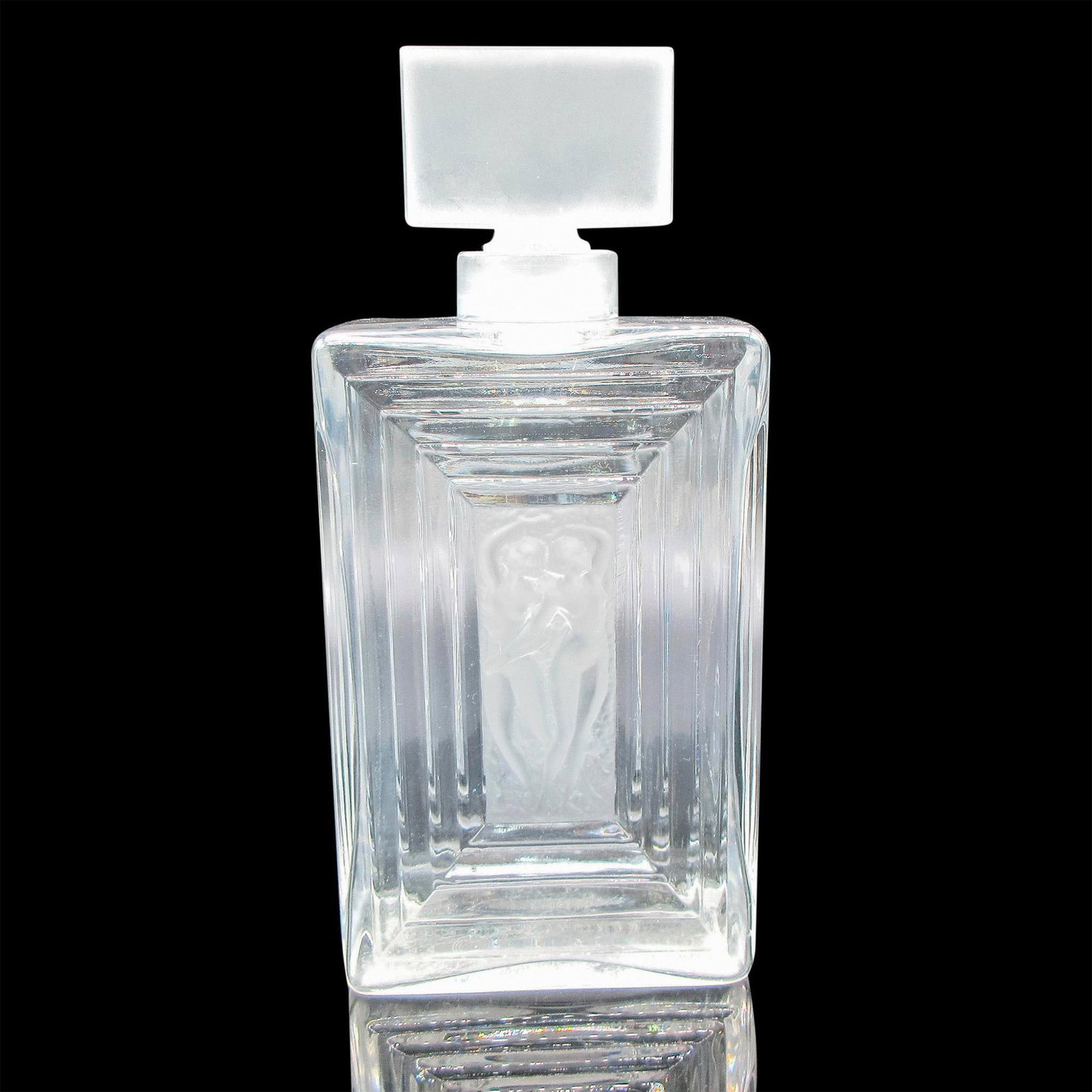 Lalique Crystal Perfume Bottle, Duncan: Clear geometric pattern around two nude frosted raised design with frosted rectangular stopper. Dimensions: 3.5"L x 2"W x 8"H Manufacturer: Lalique Country of Origin: France Provenance: Marie-Claude L