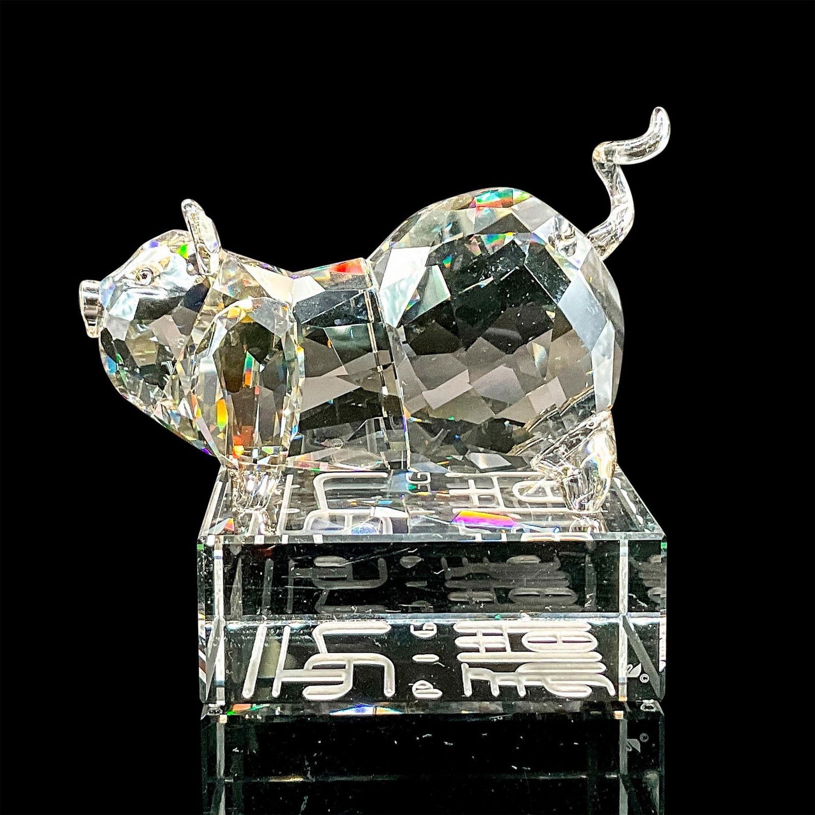 Swarovski Crystal Figurine, Chinese Zodiac Pig: Brilliant clear crystal figure of a pig standing in an alert pose. Swarovski etched backstamp. Includes original box 5.75"L x 5.75"W x 3.75"H. The zodiac name is engraved in English and Chinese script