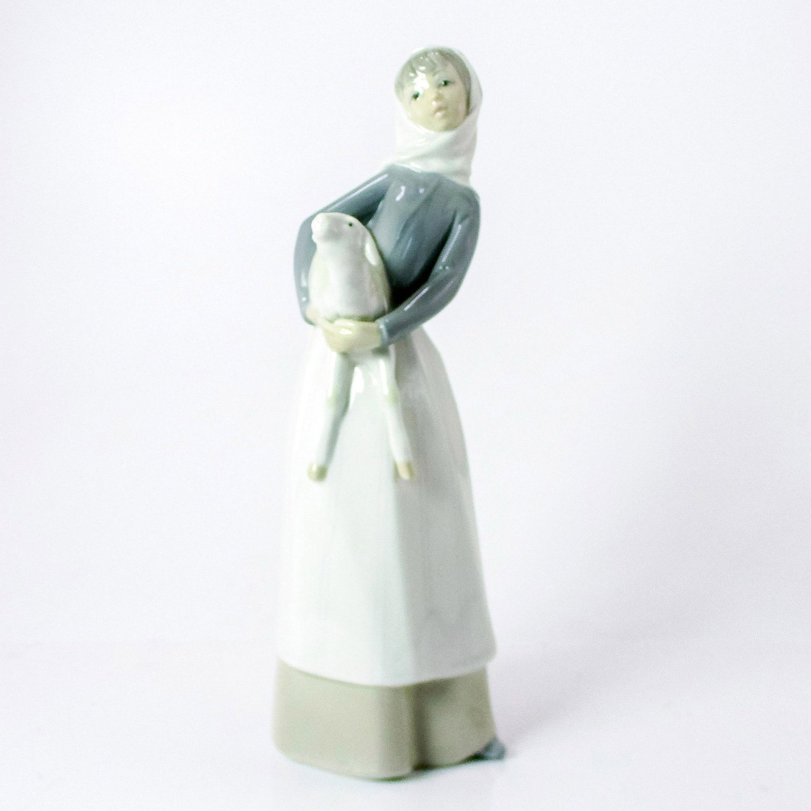Girl With Lamb 1004584 - Lladro Porcelain Figure: Glossy finish; Lladro backstamp. Artist: Alfredo Ruiz Issued: 1969-1993 Dimensions: 10.75"H x 3.25"W Manufacturer: Lladro Country of Origin: Spain