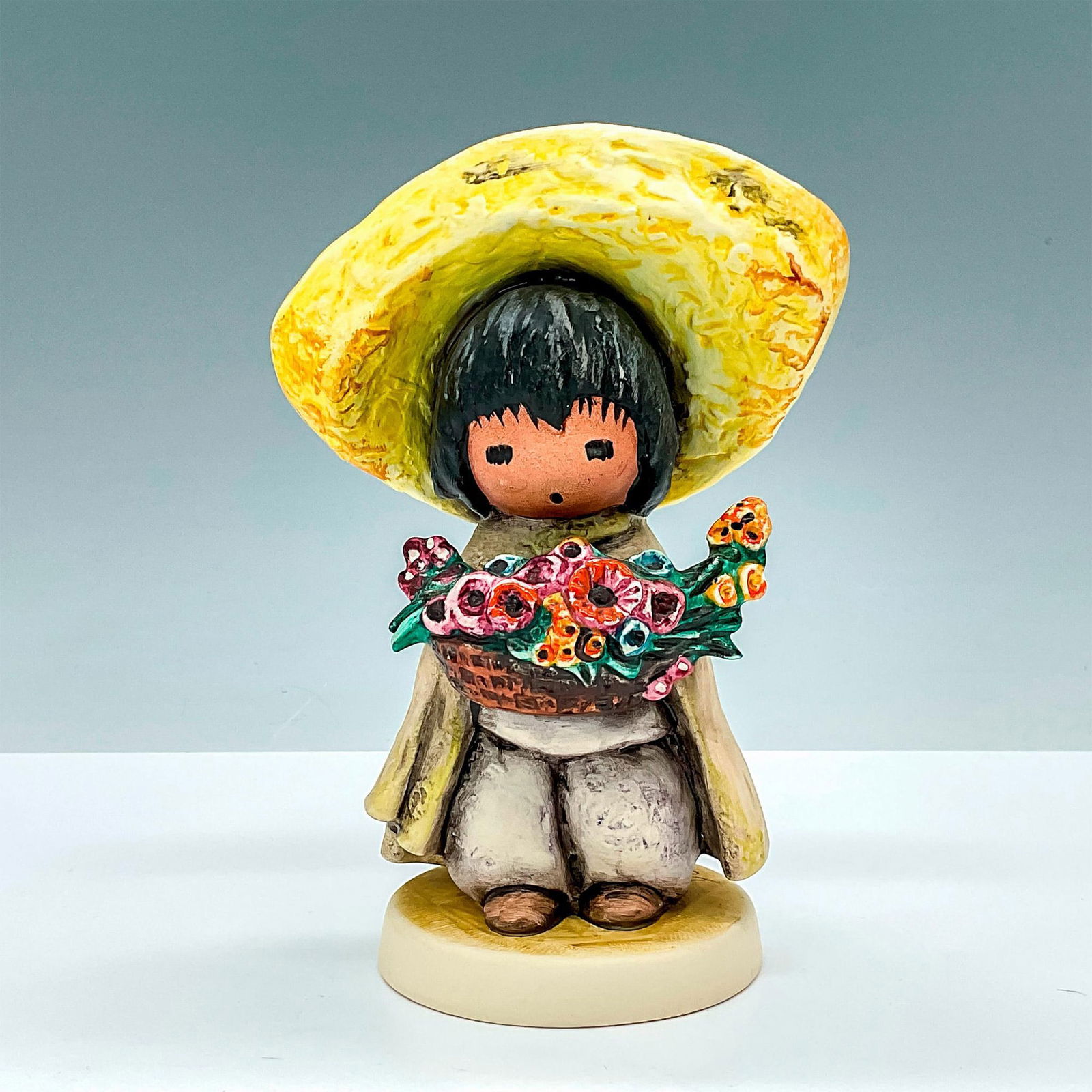Goebel by Ted DeGrazia Porcelain Figurine, Flower Boy: This Goebel by Ted DeGrazia porcelain figurine depicting a boy with colorful flowers is from The Wistful Children of De Grazia collection. This figure is incised with #1983 and 10 311 66 and painters