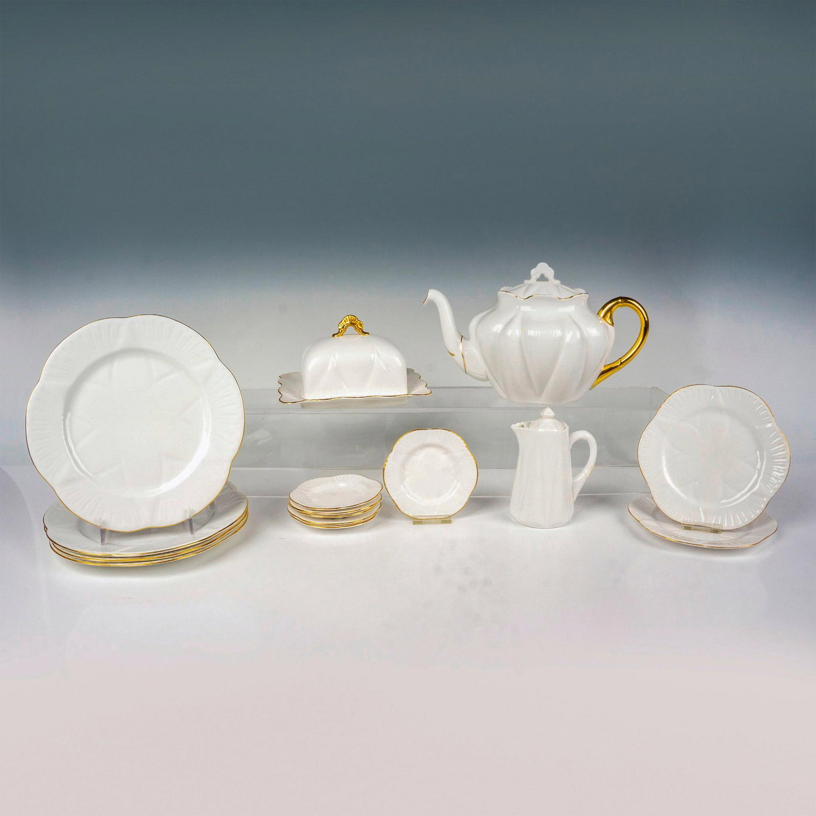 15pc Shelley Tea Grouping, White and Gold: This stunning collection of fine bone Shelley china features an elegant white design with gold rim detail. The grouping includes 4 luncheon plates (8" dia.), 2 small bread & butter plates (6" dia.), 6