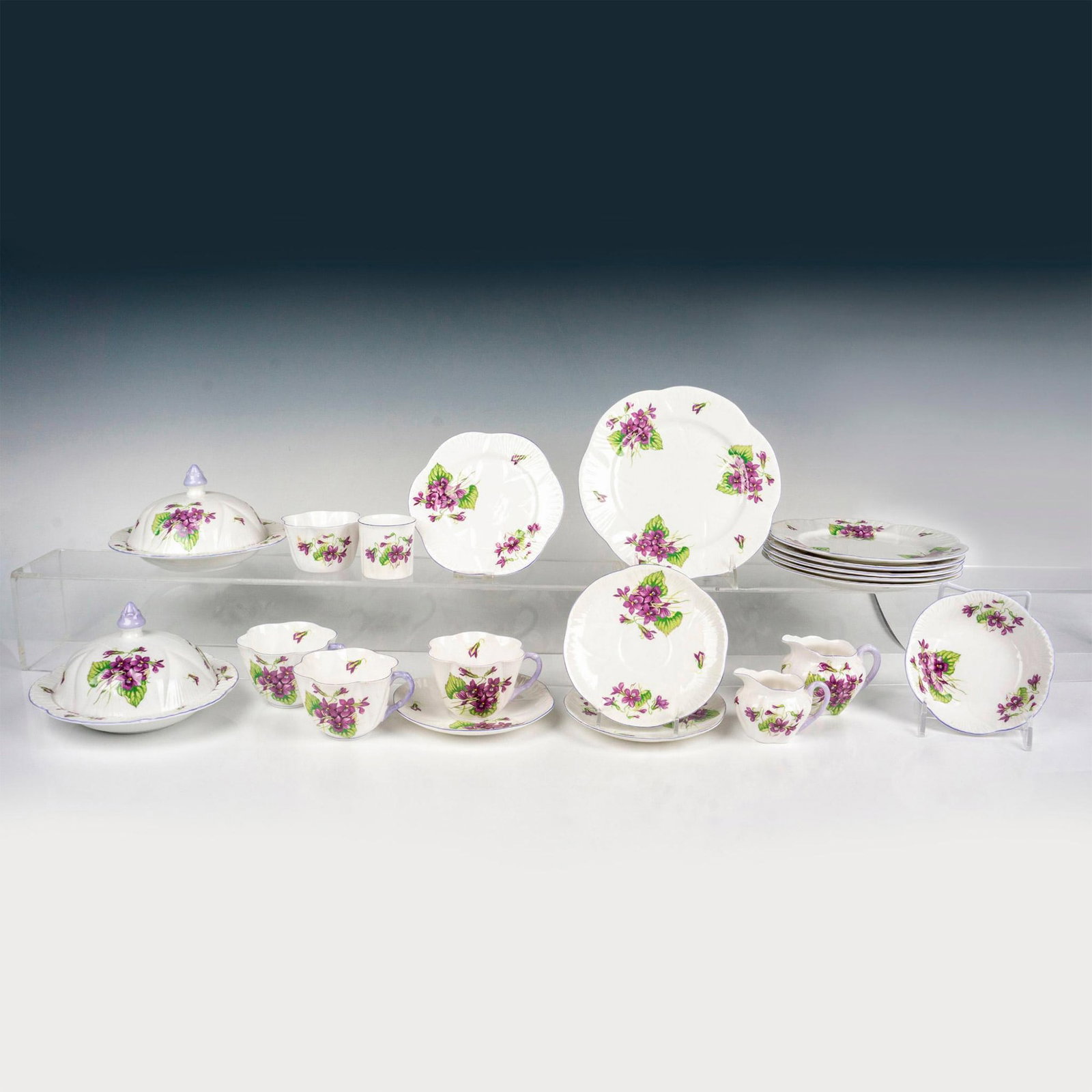 20pc Shelley China Tableware, Violets: White bone china with purple trims, and decorated in a purple flower pattern. Incudes 2 creamers, 1 open sugar bowl, 1 toothpick cup, 1 small bowl with under tray, 3 teacups with 3 saucers, 6 plates, 