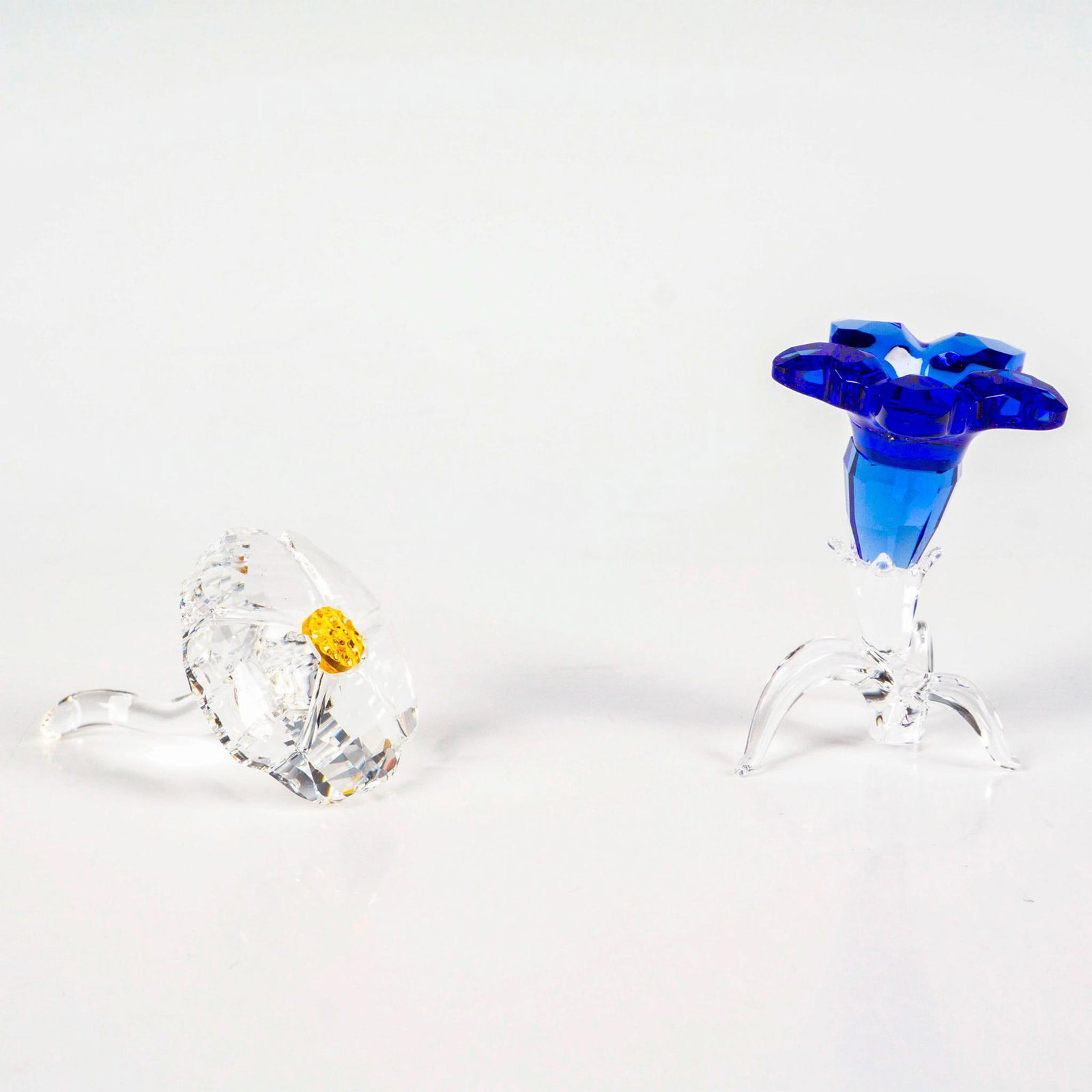 2pc Swarovski Crystal Figurines, Wild Flower + Gentian: Lead crystal pieces produced to SCS members renewing their membership. Swarovski etched backstamp. Wildflower measures: 1.5”W x 1”H. Gentian flower measures: 1”W x 1.5”H. This 