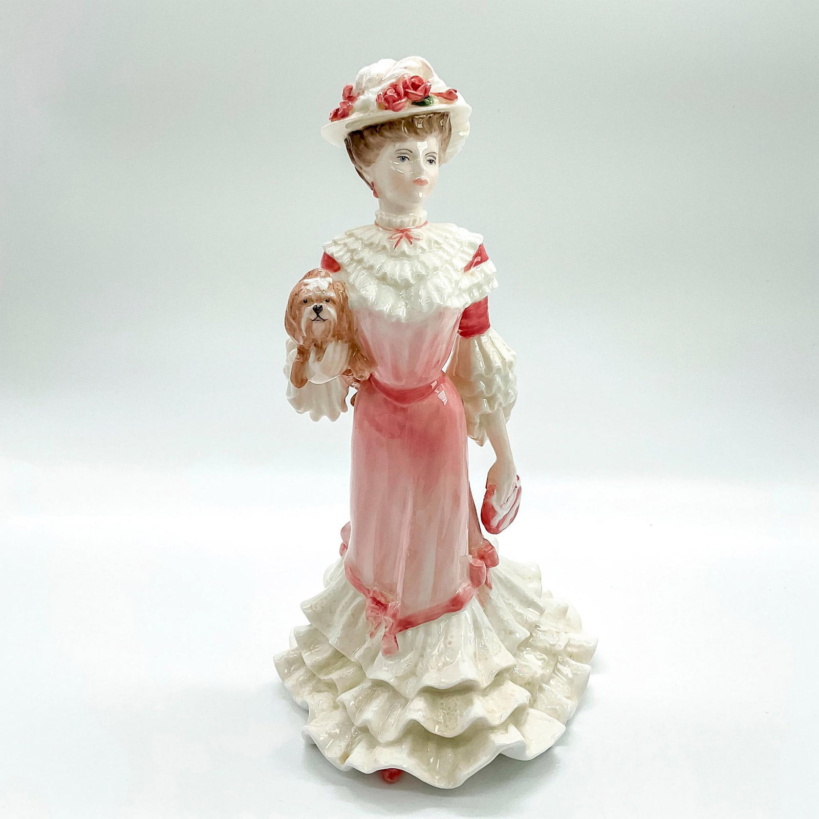 Coalport Figurine, Georgina: Limited edition bone china that is part of the Golden Age Collection. Depicts lady in a soft pink and white victorian dress with matching floral hat and handbag, holding an adorable puppy. Coalport ba