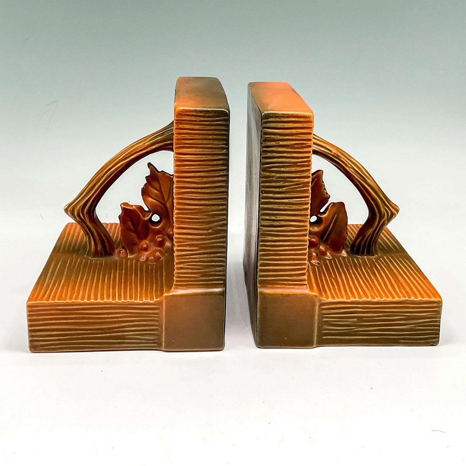 Roseville Pottery Pair of Bookends, Bushberry Brown: Square, ribbed design with branch, berries and leaves accent. Roseville USA raised mark. 9. Issued: 20th century Dimensions: 4"L x 5"W x 5.25"H Manufacturer: Roseville Country of Origin: United States