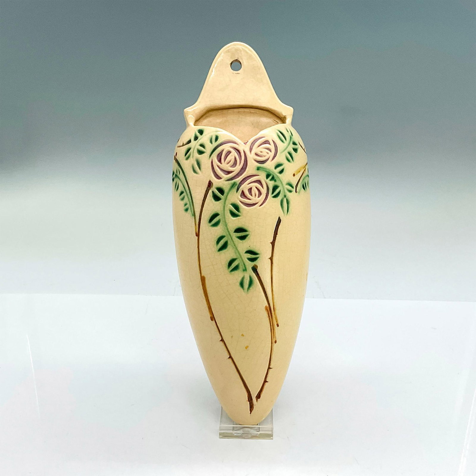 Roseville Pottery Wall Pocket, Velmoss Scroll: Earthenware wall vase with a design of Scottish roses on a thorny vine with bright green leaves impressed into a creamware body. Issued: 1917-1922 Dimensions: 11"H x 4"W x 1.75"D Manufacturer: Rosevil