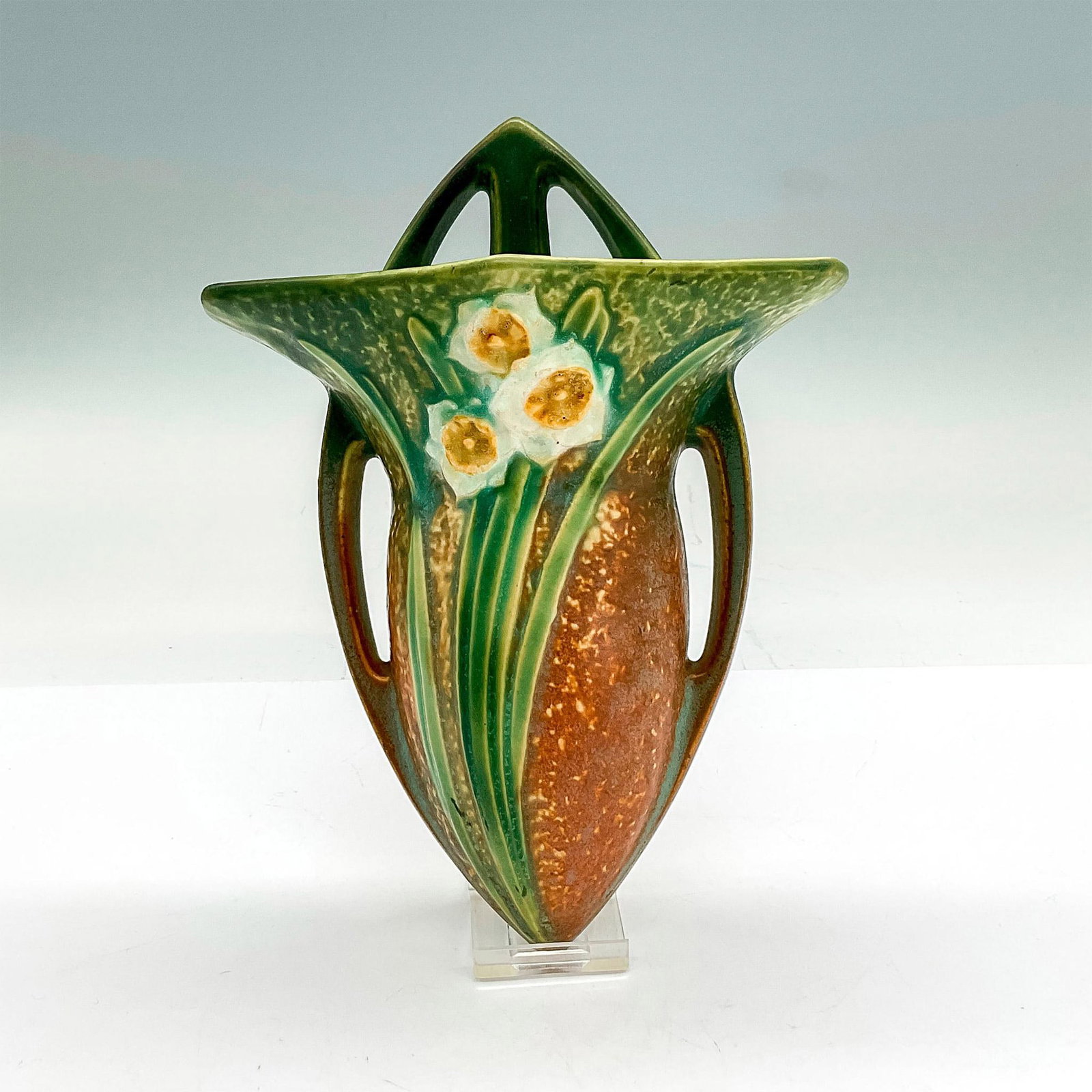 Roseville Pottery Wall Pocket, Jonquil: Earthenware wall vase in a brown bark-like textured background with a cluster of white blossoms on bright green stems. Dimensions: 8.25"H x 6.25"W x 2.25"D Manufacturer: Roseville Country of Origin: U