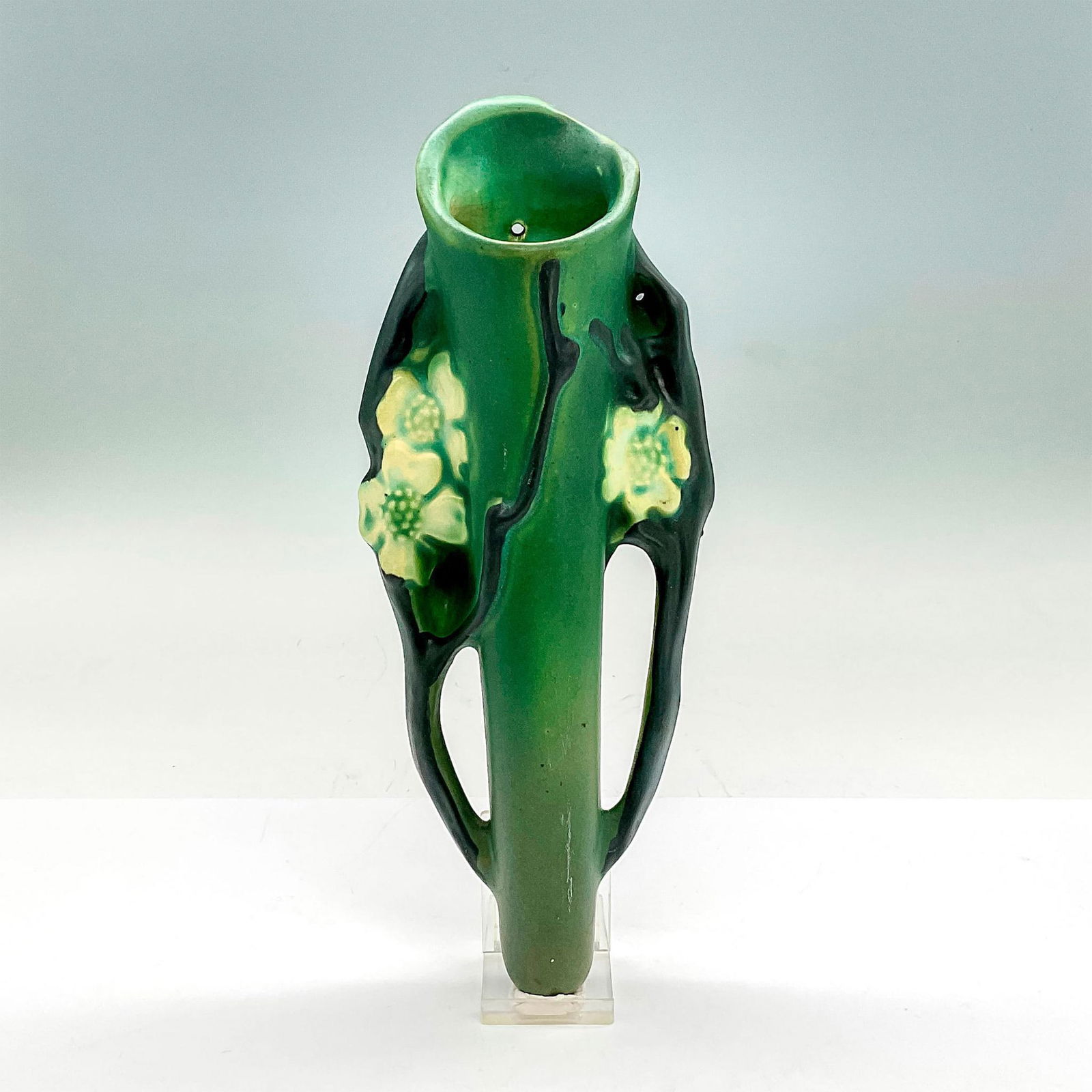 Roseville Pottery Wall Pocket, Dogwood: Earthenware wall vase in a pattern that features flowering dogwood branches of white flowers on a deep green background. Dimensions: 10.25"H x 4"W x 2"D Manufacturer: Roseville Country of Origin: Unit