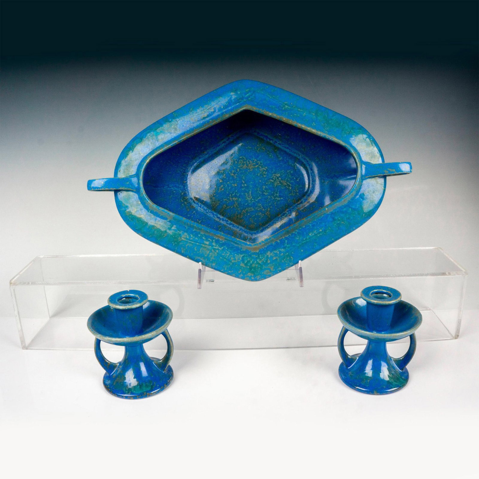 3pcs Roseville Pottery Blue Console Bowl and Candle Holders: Three pieces painted in a great mottled blue glaze. The two candle holders have Roseville stickers on the bottoms and measure 4"dia. x 4.25"H. The handled console bowl measures 16"L x 10.25"W x 2.5"H.