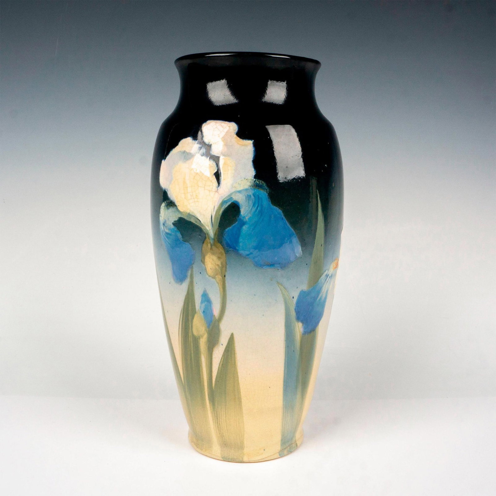 Roseville Pottery Artist Signed Iris Vase: Nice detailed tall vessel hand decorated featuring large iris flowers and its foliage set against a glazed gradient ground. L. Mitchell signed to side. Artist: Lillie Mitchell Dimensions: 6"W x 13"H M