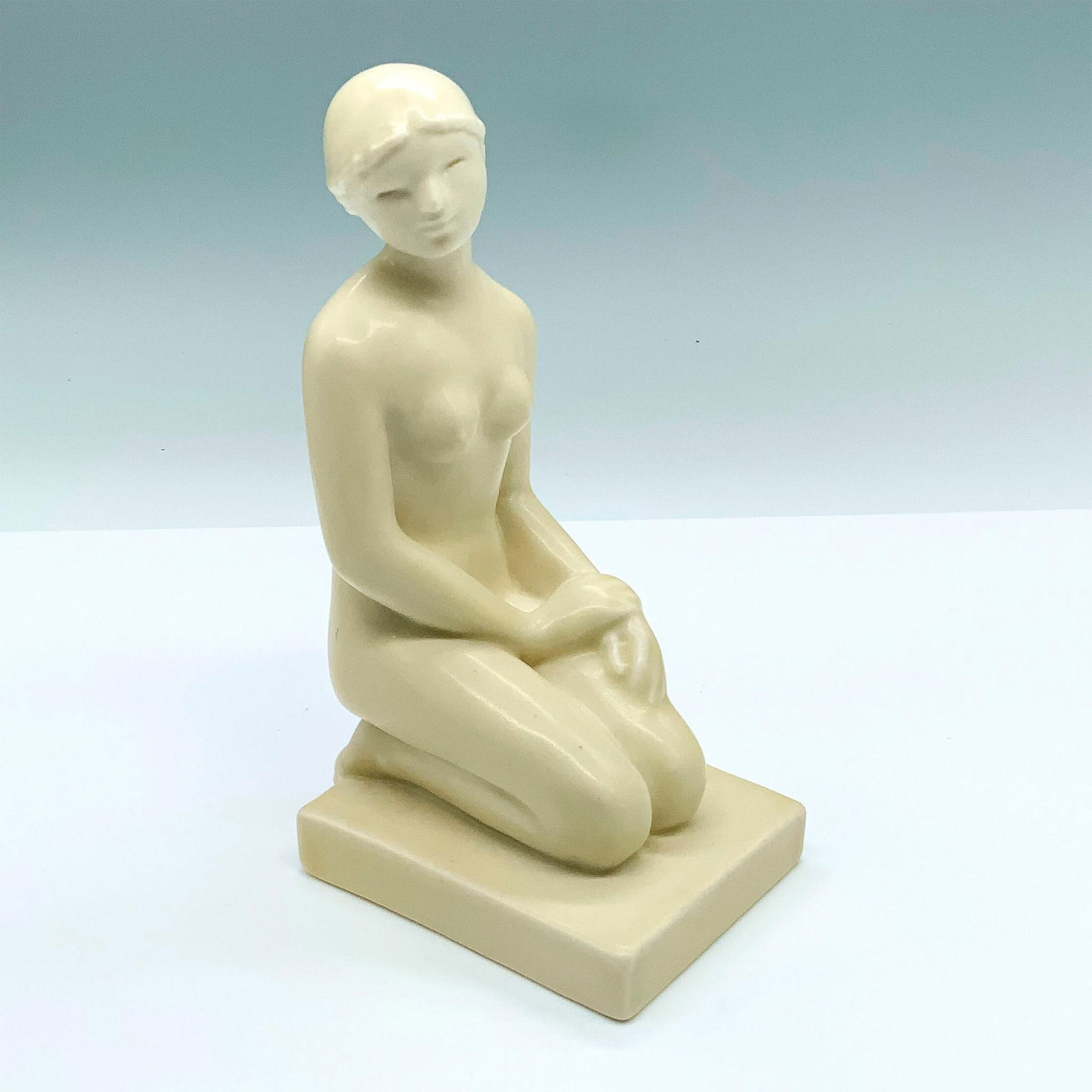 Rookwood Pottery Kneeling Nude Woman Figurine #6159: Figure of a kneeling female nude with cream colored porcelain high glaze. Marked with the Rookwood symbol, 6159, and Louise Abel's mold mark. Artist: Louise Abel Issued: 1930 Dimensions: 4"L x 3"W x 7