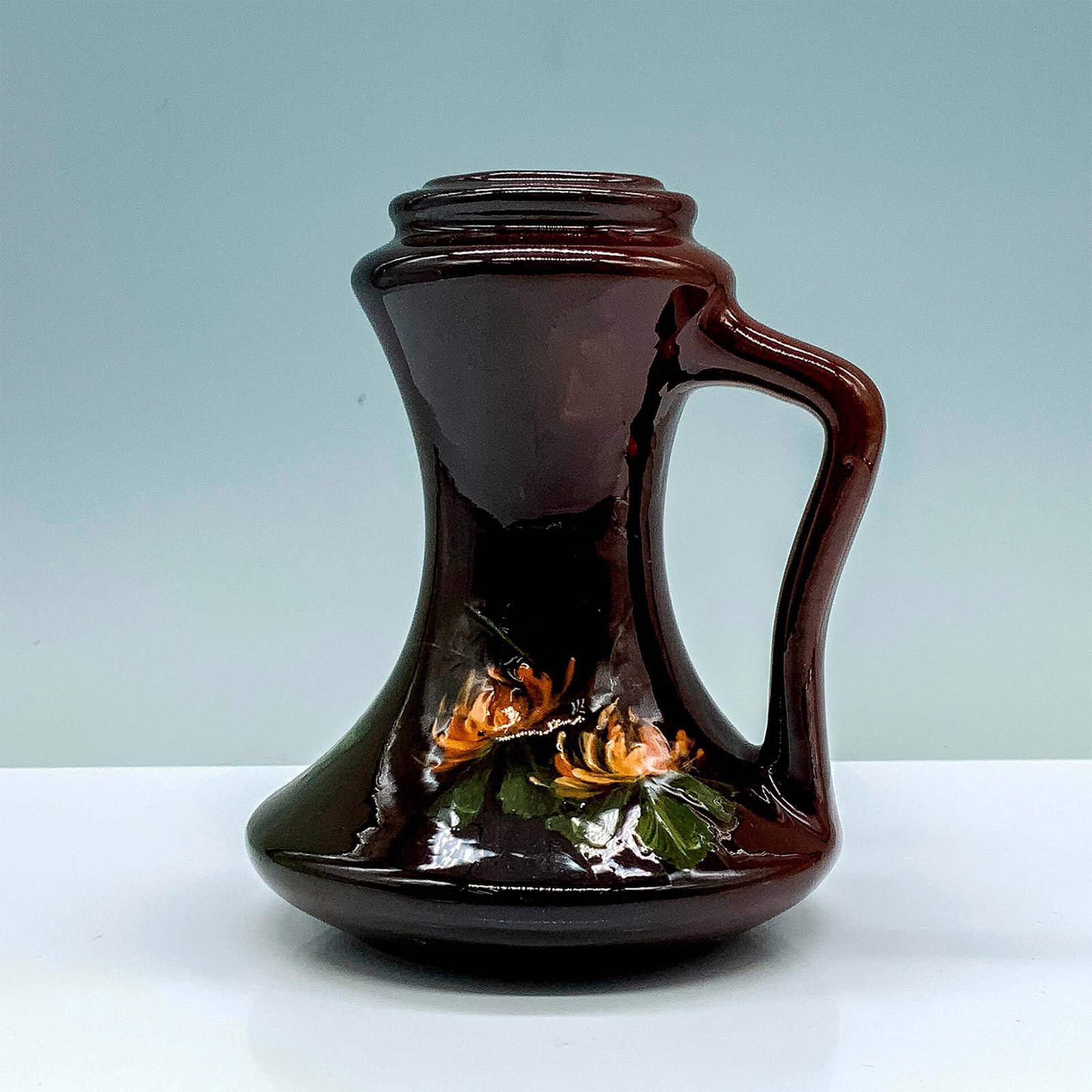 Weller Louwelsa Art Pottery Candleholder: A brown colored candle holder that is painted with pink flowers and their foliage. Weller Louwelsa marking. Manufacturer: Weller Country of Origin: United States