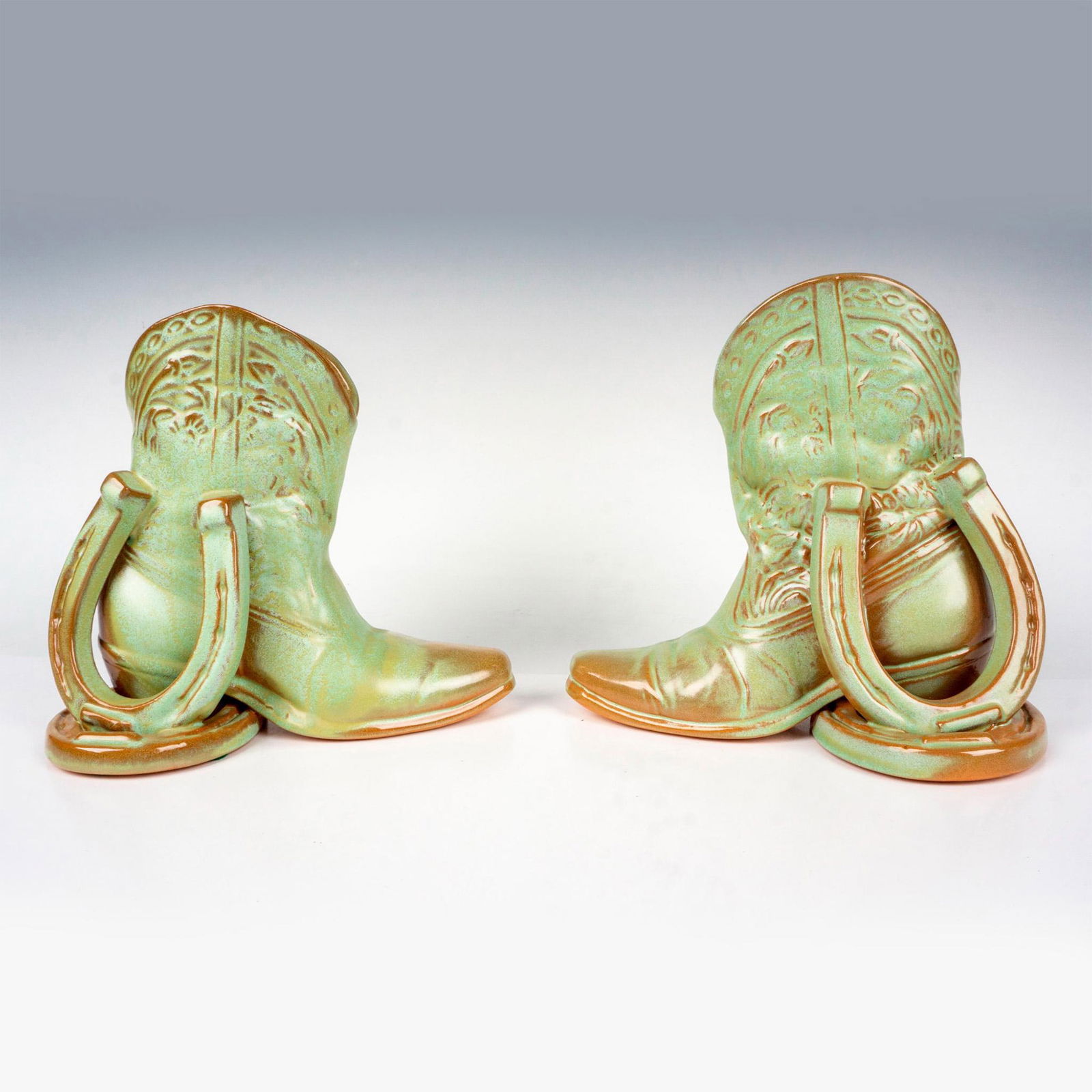 Pair of Vintage Frankoma Pottery Boot Bookends: 2 green and brown bookends molded as a western boot and horseshoes. Frankoma Pottery marked on the base. Measurement for 1 bookend: 7.5"L x 4.25"W x 7"H. Measurements for both bookends: 8.5"L x 7.5"W