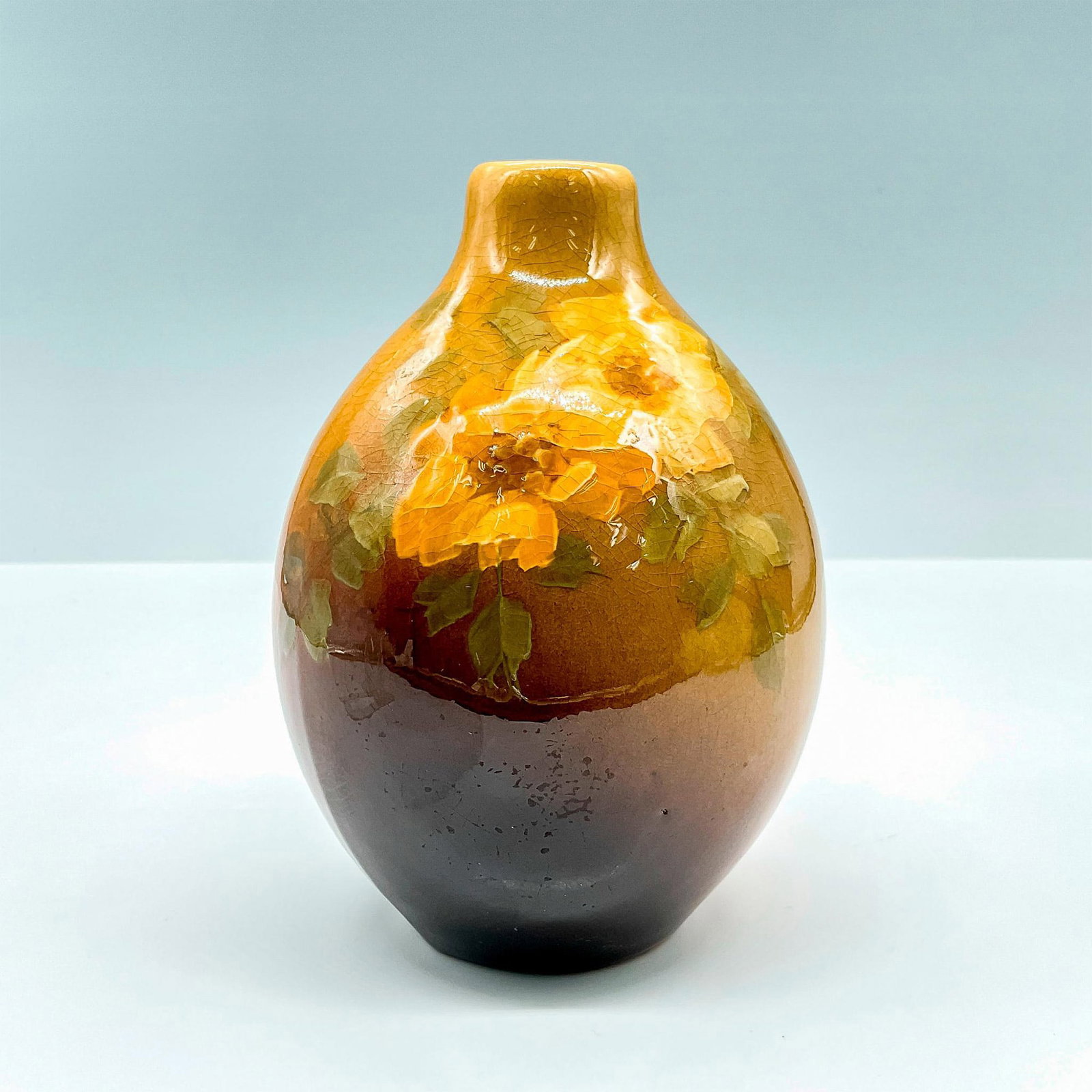 J. B. Owens Art Pottery Bud Vase, Utopia #1048: Lovely high gloss glaze over rich yellow and brown toned narrow neck vase decorated with hand painted flowers. J.B. Owens #1048 stamped to base. Issued: 20th Century Dimensions: 3.75"L x 0.75"W x 5.25