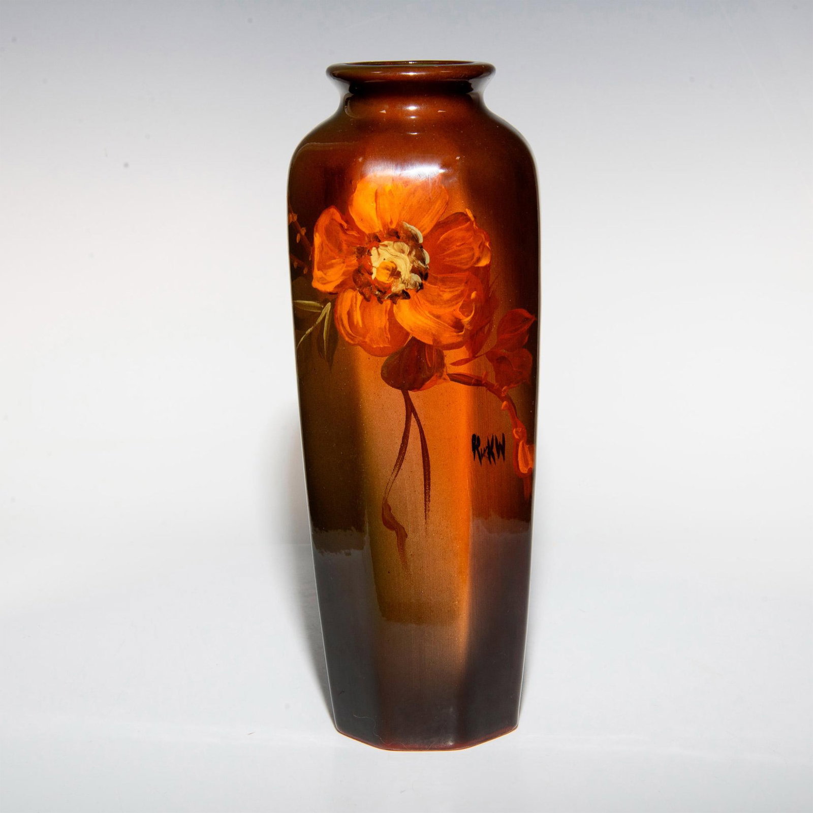 Rick Wisecarver Pottery Vase: Hand painted vessel depicting a single flower design over a brown glaze ground. Artist signed and dated. Artist: Rick Wisecarver Issued: 1983 Dimensions: 3.5"W x 10.25"H Country of Origin: United Stat