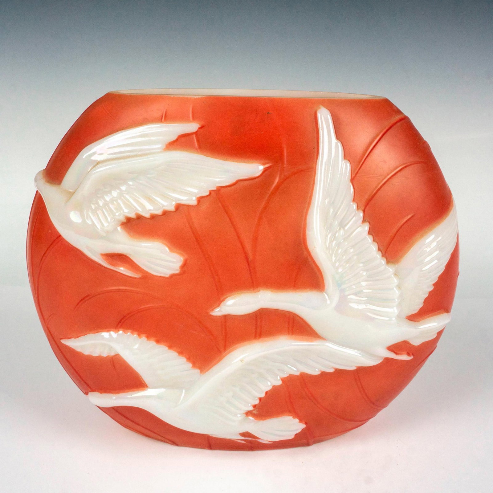 Consolidated Phoenix Glass Pillow Vase, Geese: A striking layered glass vessel, boasting raised flying geese on both sides and a white milk glass interior. For a short time during the 1930w, Phoenix Glass company had the molds on loan from the Con