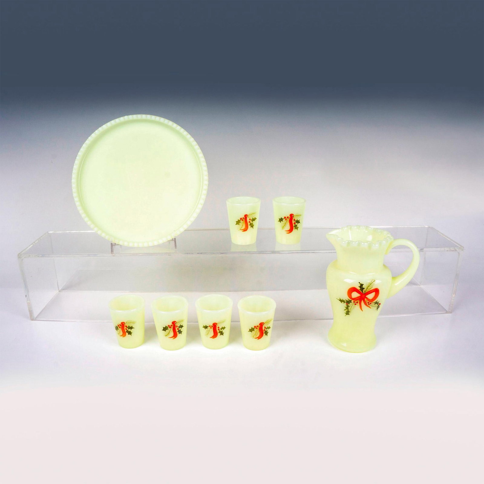 8pc Fenton Uranium Glass Childrens Lemonade Set, Signed: Nice set including 1 pitcher, 6 glass mini tumblers, and 1 round tray. Features a festive hand painted design. Artist signed to underside. Pitcher measures: 4"L x 3"W x 5.75"H. Tumblers measure: 1.75"