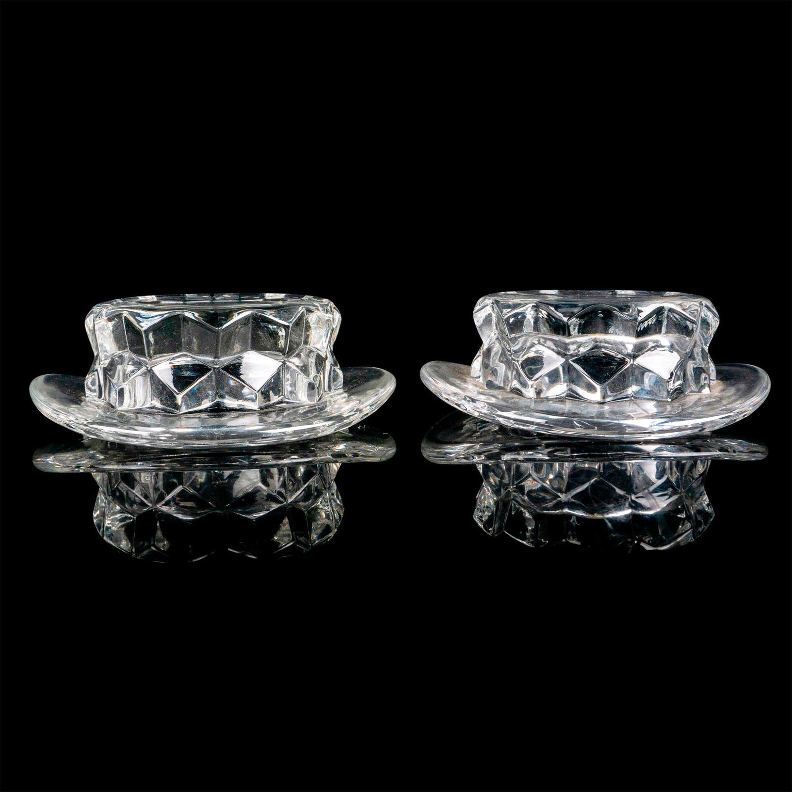 Pair of Fostoria Ashtrays, American Clear: Pressed glass vessels in the shape of a hat decorated with a cubed motif. Issued: 1915-1982 Dimensions: 3.75”L x 3.75”W x 1”H Manufacturer: Fostoria Country of Origin: United States