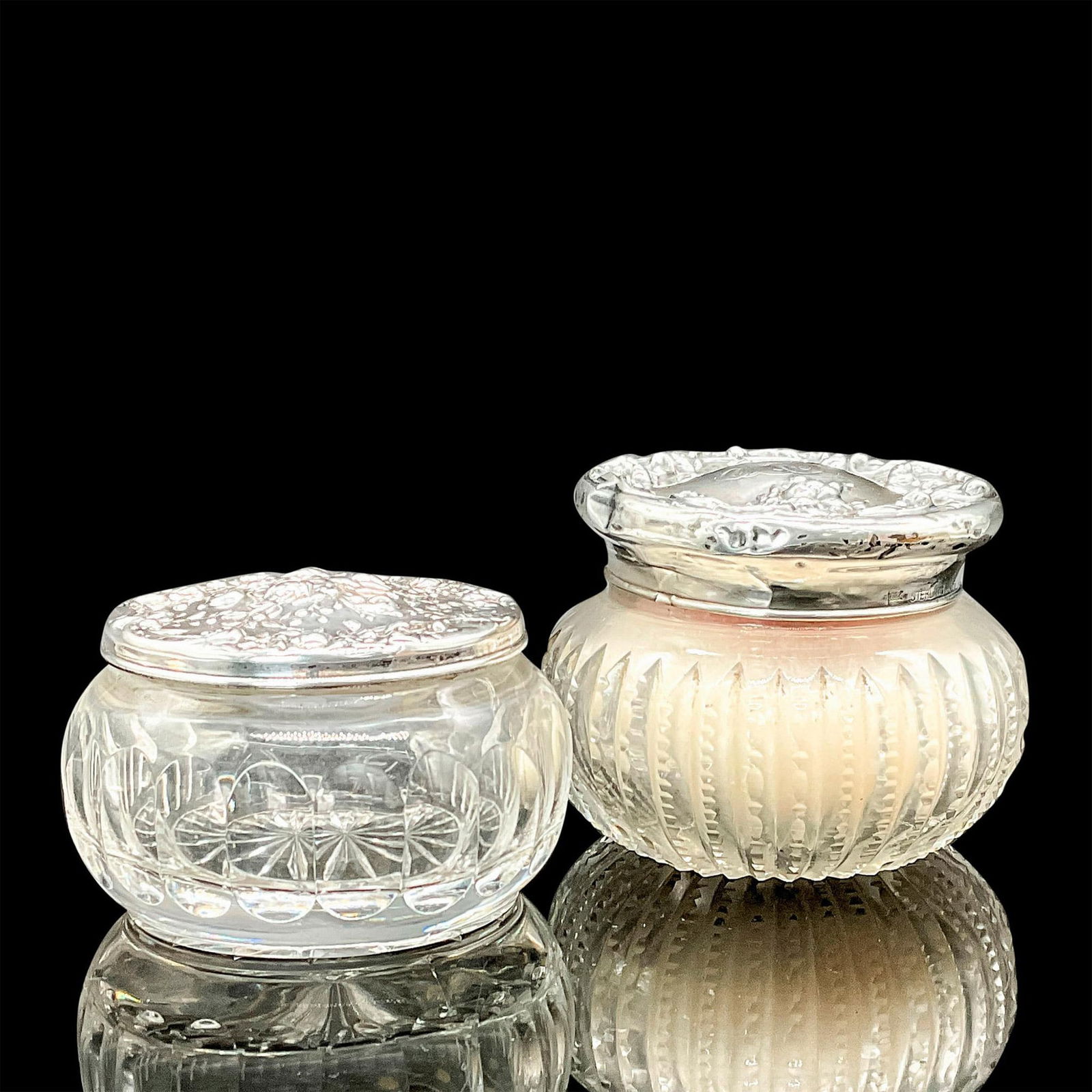 2pc Vintage Crystal and Gorham Silver Powder Jars: Two elegant crystal powder jars with repousse silver lids, one sterling (22g). The smaller jar is stamped Gorham to lid with a sticker on the jar, it measures 2.25"H x 3.75"dia. The larger jar 3"H x 4