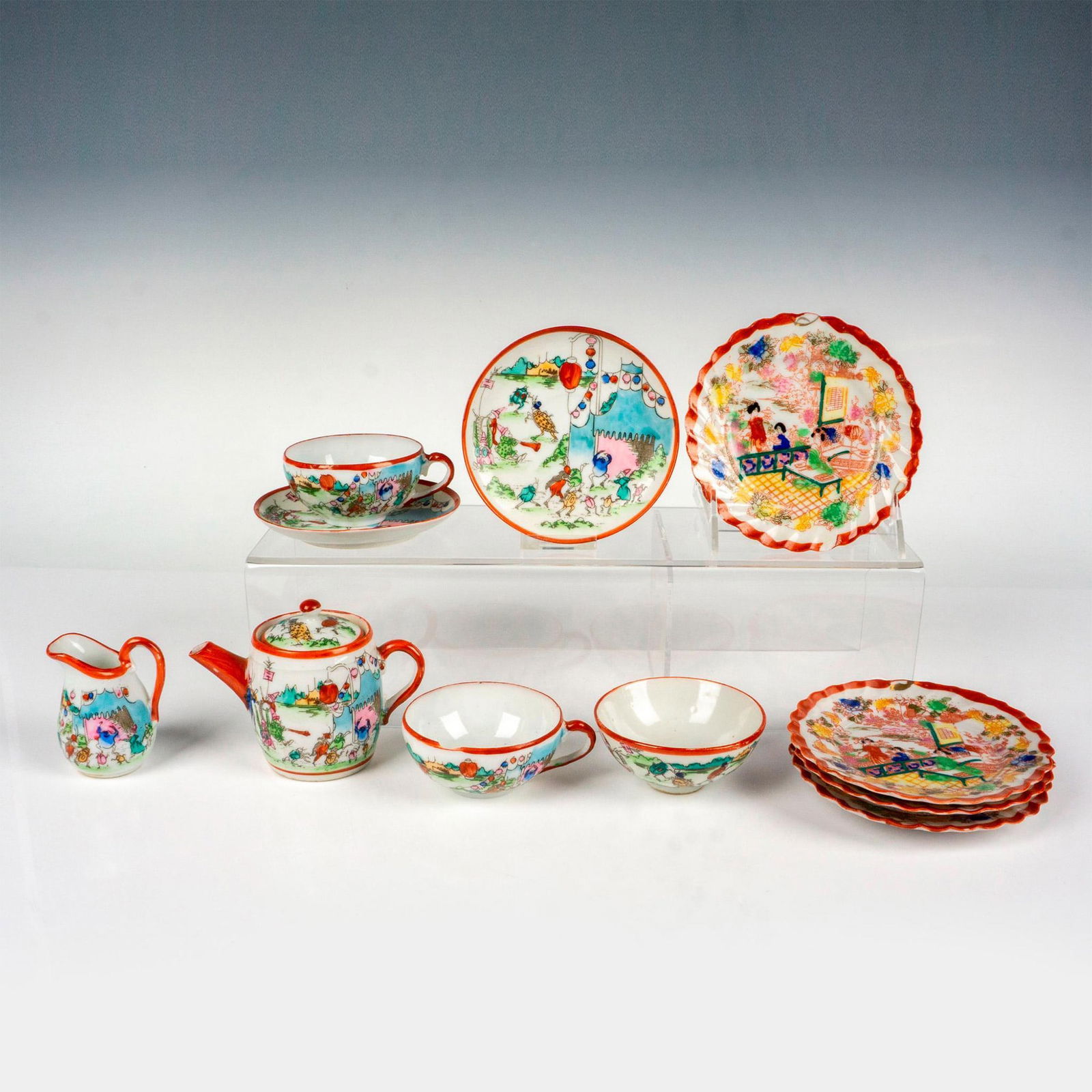 11pc Japanese Porcelain Children's Tea Set: Hand painted set that includes 1 lidded teapot, 1 creamer, 1 open sugar bowl, 2 cups, 2 saucers, and 4 side plates. Features Japanese Geisha woman and insects at a carnival. Japan marked to underside