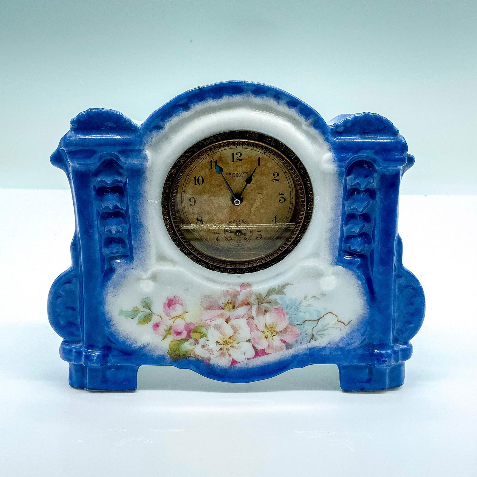 Rare Antique Porcelain New Haven Floral Clock: Glossy porcelain clock decorated with flowers. Stamped 8770 on bottom. Dimensions: 6.5"L x 1.5"W x 5.25"H Manufacturer: New Haven Clock Company Country of Origin: United States
