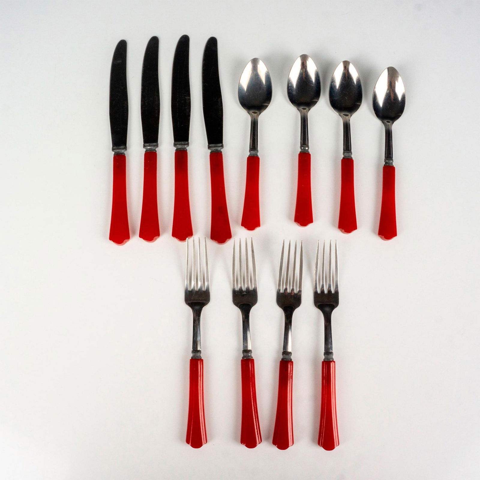 12pc Vintage Red Bakelite Silverware, Forks, Knives, Spoons: This vintage silverware grouping includes 4 forks, 4 spoons, and 4 knives all finished with red Bakelite handle. Metal part is stamped Stainless Steel.