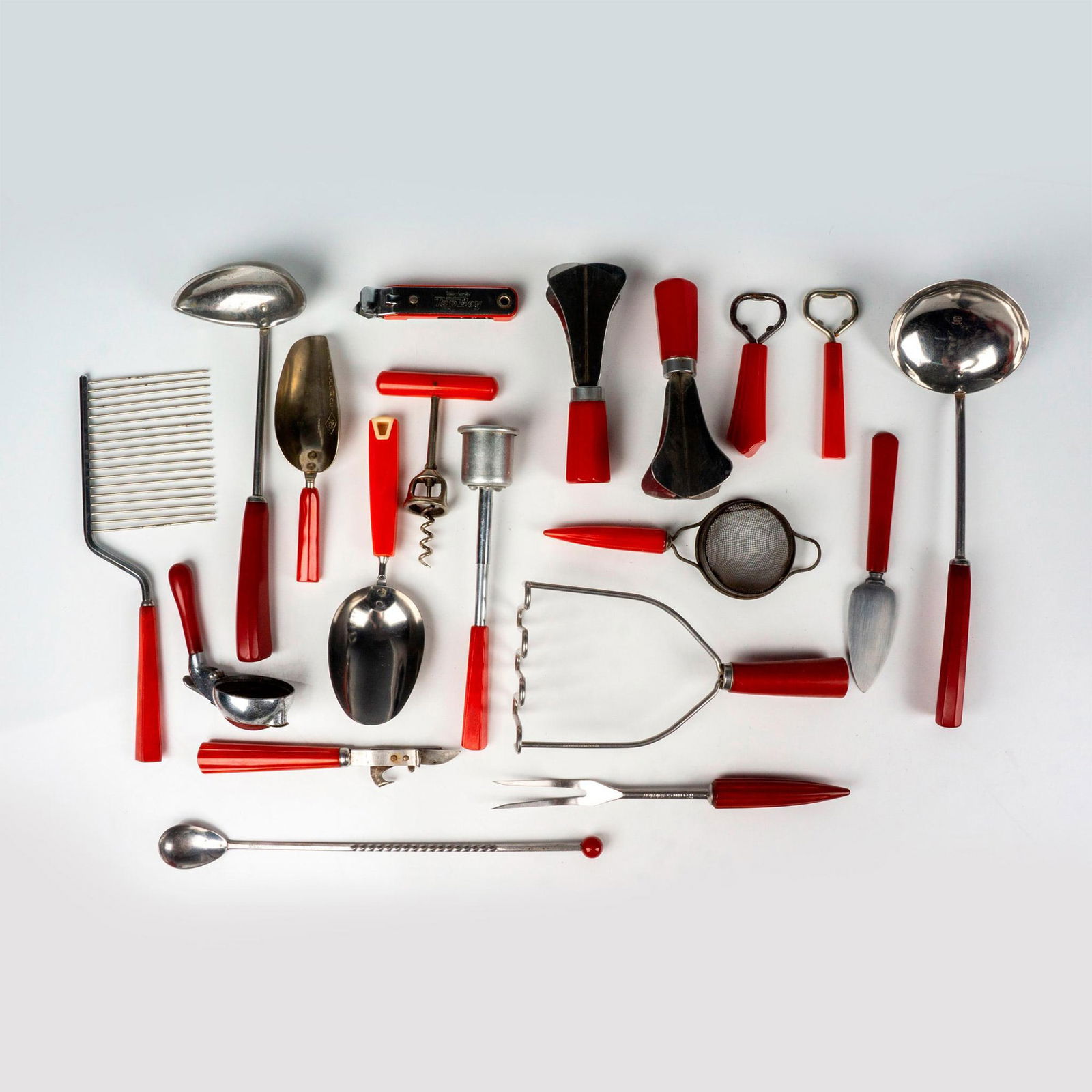 19pc Vintage Red Bakelite Kitchen Utensils: This retro kitchen utensil grouping includes 2 food choppers, 2 scoops, small sieve, 2 ladles, masher, cake cutter, serving fork, cheese spade, syrup lid, 2 can openers, cocktail spoon, 2 bottle opene