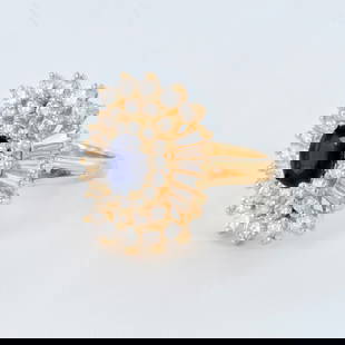 Harold Freeman 14K Yellow Gold, Sapphire, and Diamond Ring: Oval 1.10ct sapphire in the center with four prong setting surrounded by 44 brilliant and baguette-cut diamonds weighing 2.50cts. 14k yellow gold weighing 7.47g. Stamped EREV inside. Size 6.25. Artist