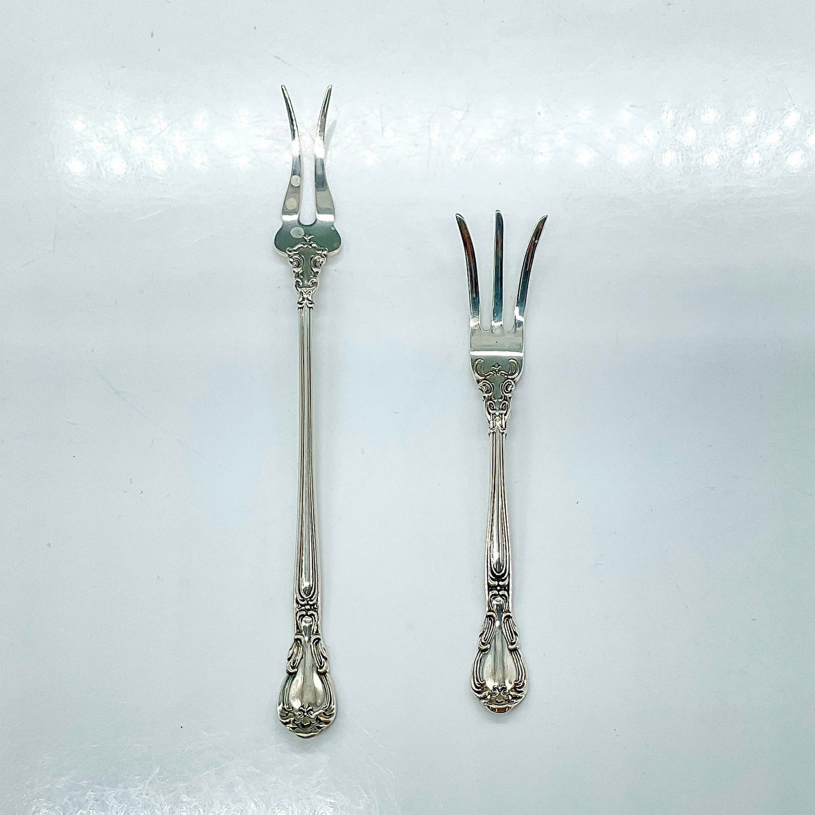 2pc Gorham Sterling Silver Small Serving Forks, Chantilly: Sterling silver small lemon and olive serving forks with an elegant scroll and fleur-de-lis accent design. Stamped Gorham and Patent 1895 Sterling. The longest is 5.75"L. Manufacturer: Gorham Country