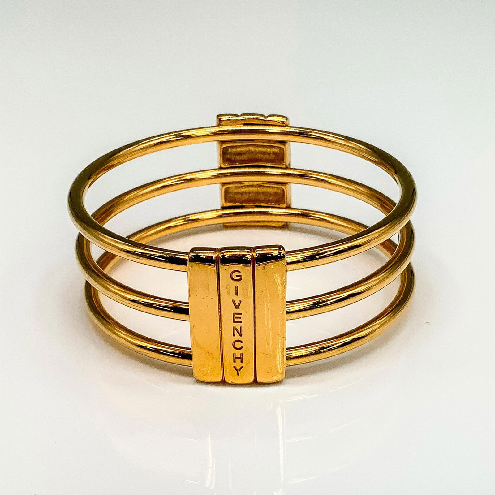 Pretty Givenchy Gold Metal Layered Cuff Bracelet: Gold tone bracelet with Givenchy stamp. The inside measures 2.5"dia. Dimensions: 2.5"dia. x 1"W Manufacturer: Givenchy Country of Origin: France
