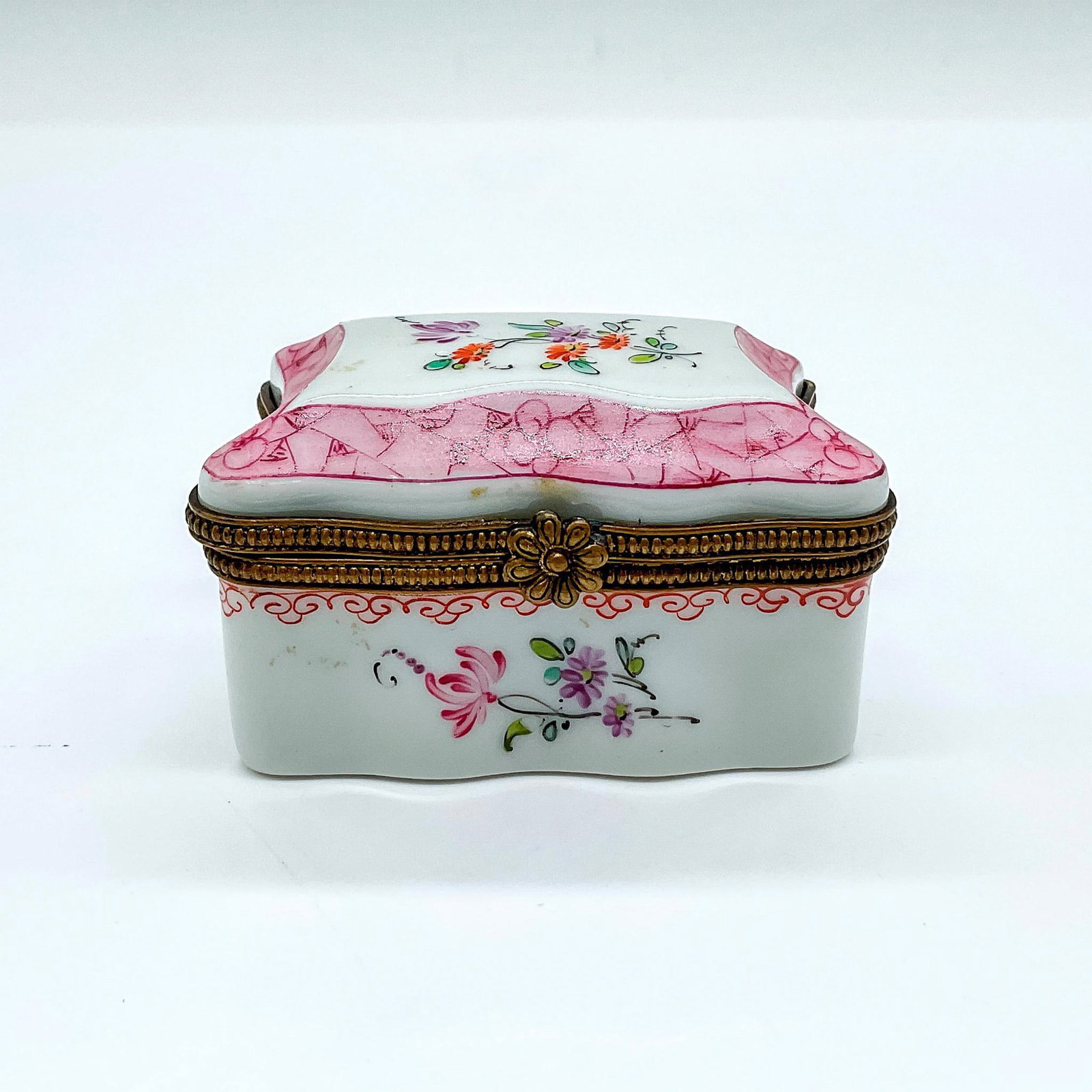 M.M.T. Porcelain Limoges Floral Box: A pink and white box adorned in a hand painted flower motif. Artist's monogram and Limoges France stamped on the base. Artist: M.M.T. Dimensions: 2.5"L x 2"W x 1.5"H Country of Origin: France
