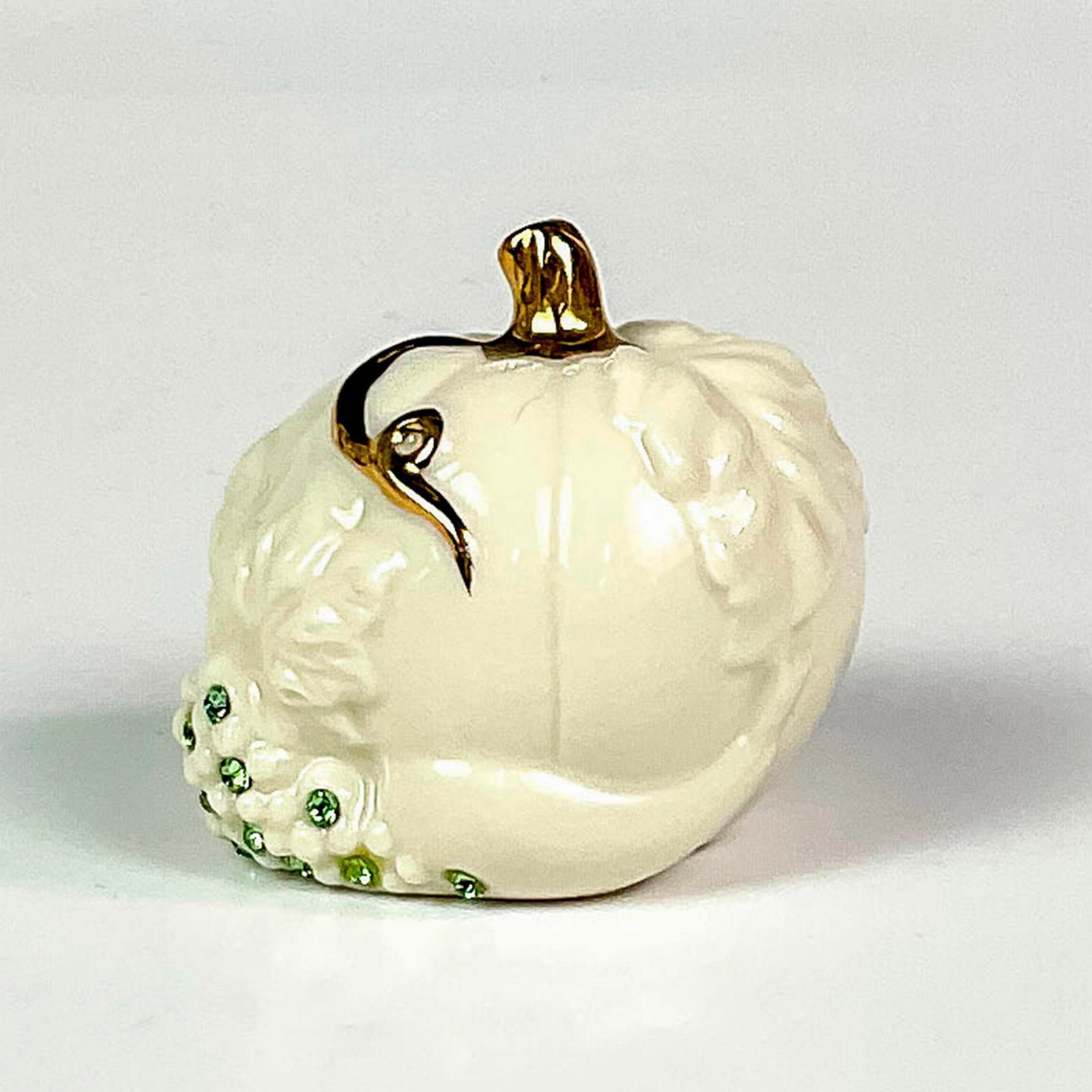 Pair of Lenox Porcelain Pumpkin Shakers: A charming set of salt and pepper shakers in the shape of pumpkins; decorated with green crystals and gilded stems. Lenox backstamp. Dimensions: 2"L x 1.75"W x 1.75"H Manufacturer: Lenox Country of Or