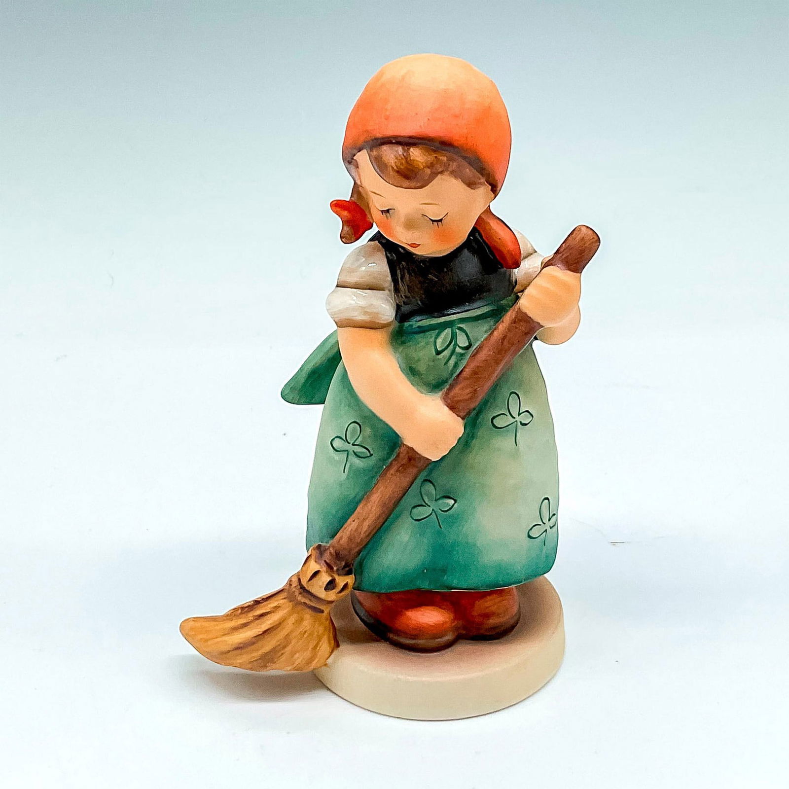 Goebel Hummel Porcelain Figurine, Little Sweeper: Matte finished figural colored in orange and green holding broom. Goebel backstamp. M.I. Hummel impressed mark. 171. This item has its original box: 6.25"L x 4"W x 3.5"H. Issued: 20th century Dimensio