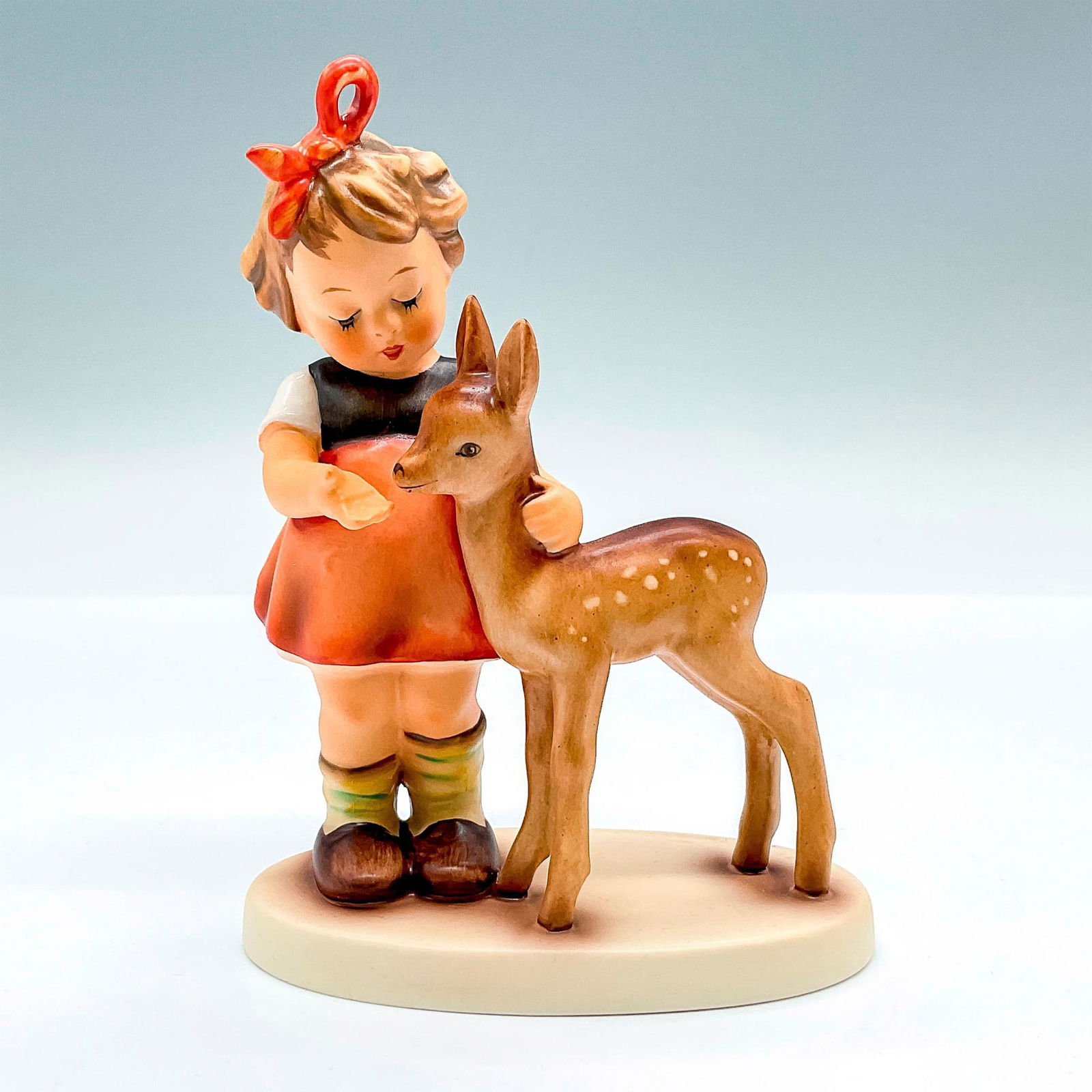 Goebel Hummel Porcelain Figurine, Friends HUM 136/I: Hand painted figure of a young girl with a fawn. Goebel backstamp. This item has its original box: 7.5"L x 5"W x 3.5"H. Artist: M.I. Hummel Issued: 1992 Dimensions: 3.75"L x 2.25"W x 5"H Manufacturer: