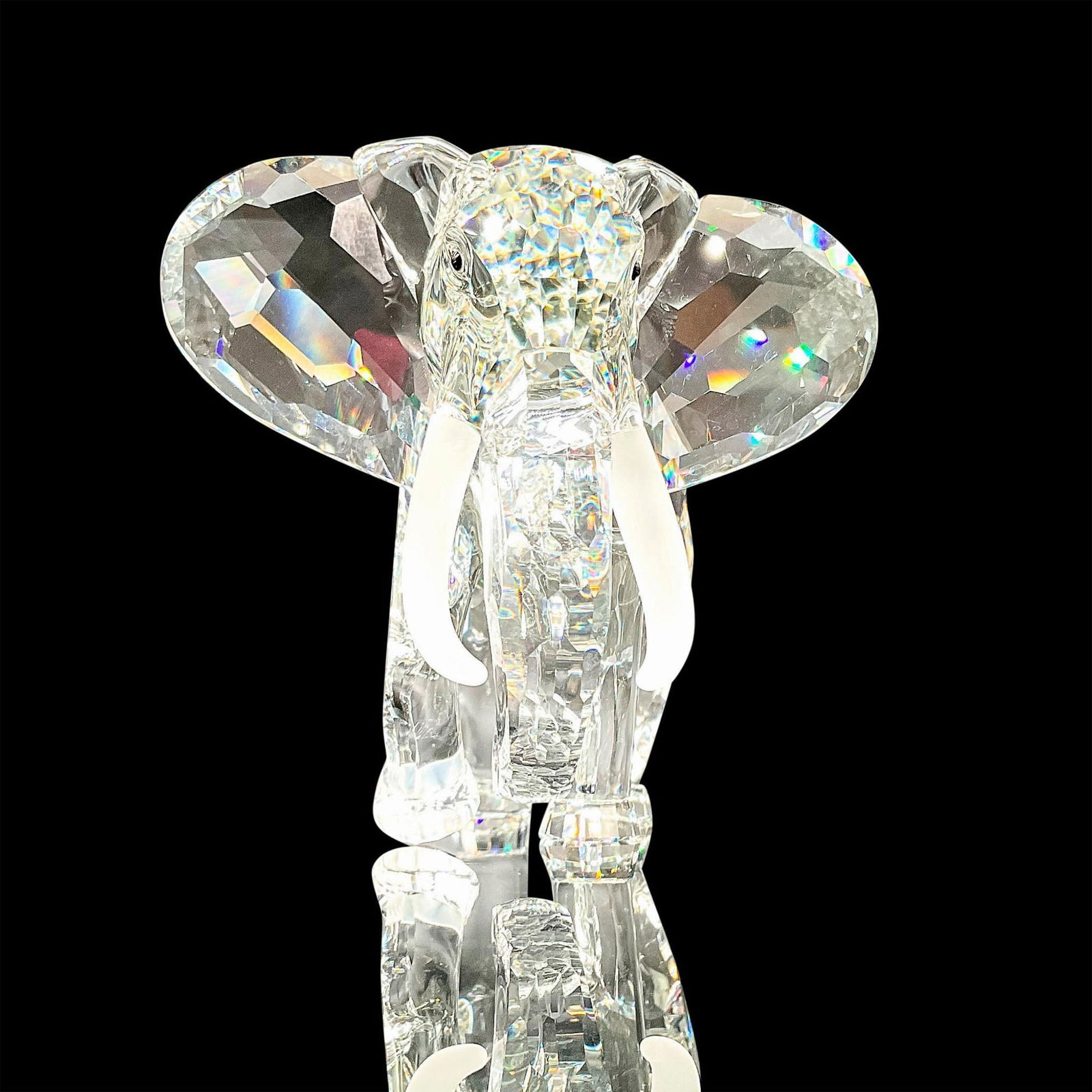Swarovski Crystal Figurine, The Elephant + Base: From the Inspiration Africa collection. Faceted crystal figurine modeled as an African elephant with large ears and frosted crystal tusks. Swarovski acid mark to base. Artist's signature inscribed to