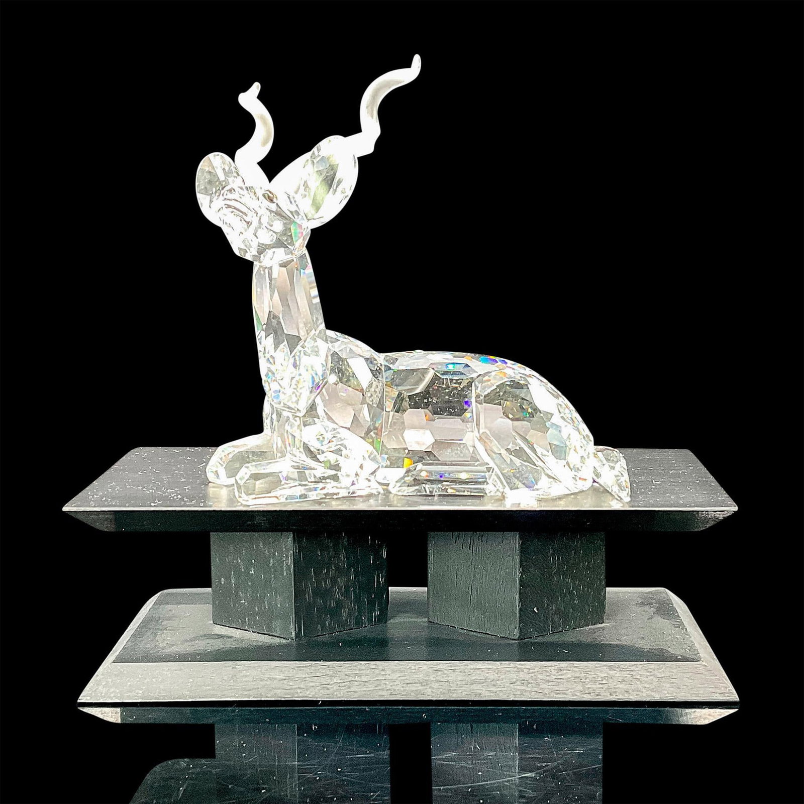 Swarovski Crystal Figurine Kudu with Base: Available only during 1994 to SCS members, this Kudu features a faceted clear crystal body with frosted antlers and black eyes. Etched Swarovski backstamp. This item has a base included. Includes blac