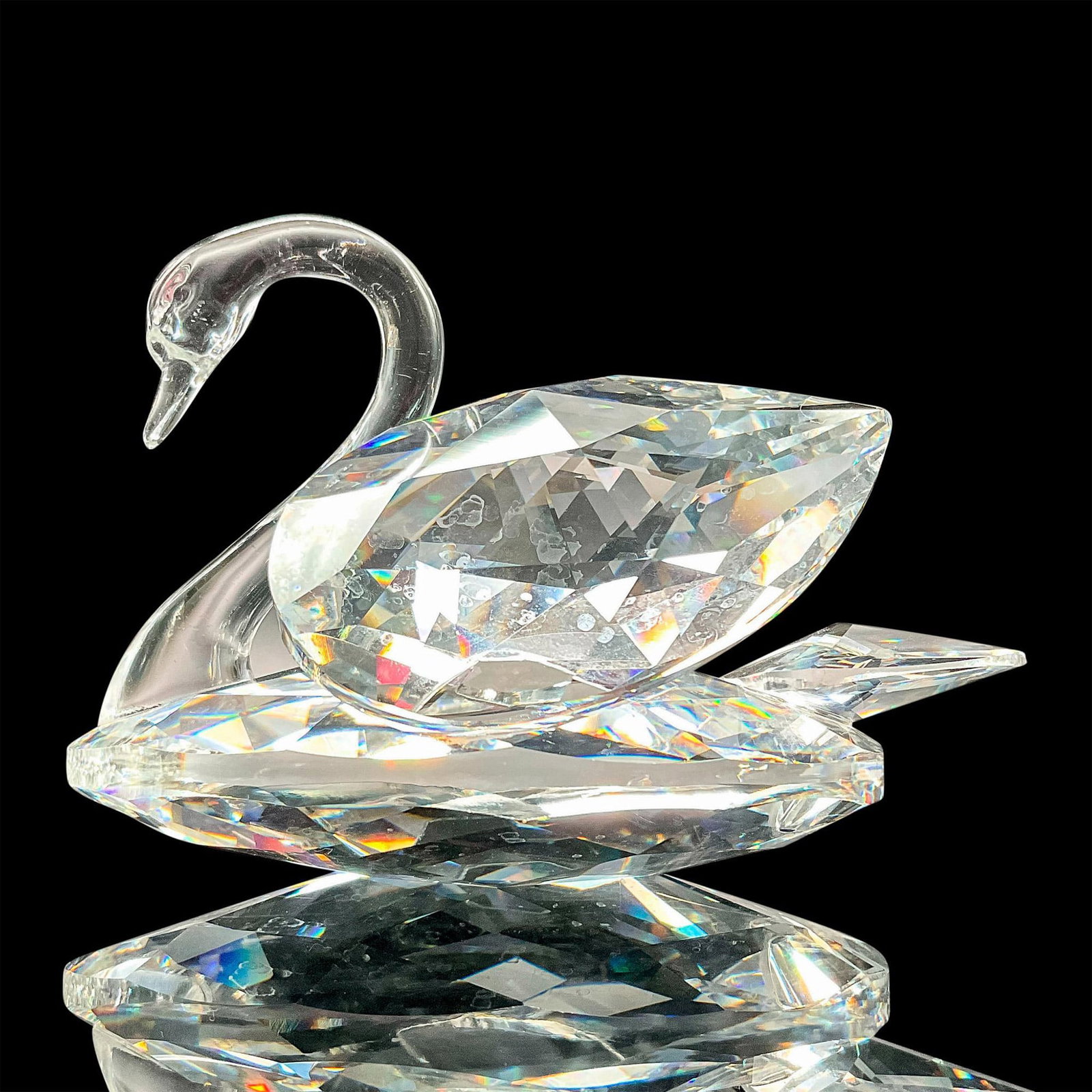 Swarovski Crystal Figurine, Swan: Faceted crystal figurine modeled as a swan with a graceful molded crystal neck. Swarovski acid mark to base. Dimensions: 3"L x 2.75"W x 1.75"H Manufacturer: Swarovski Country of Origin: Austria