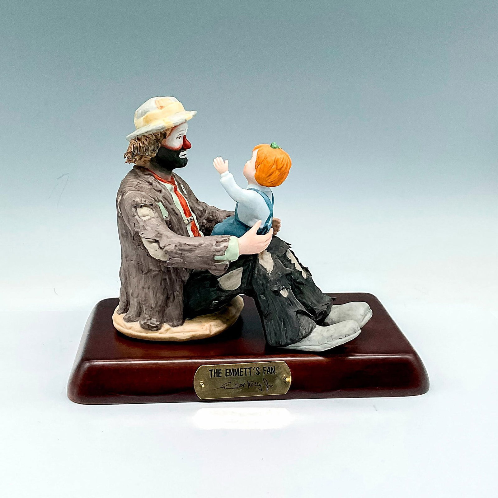 Flambro Imports Figurine, Emmett Kelly, Jr. The Emmett's Fan: Part of the EKJ Collection - Matte finished porcelain figural in tattered dress bouncing child on his knees. Limited edition 9356 of 12000. Flambro Imports backstamp. This item has a base included: 9"