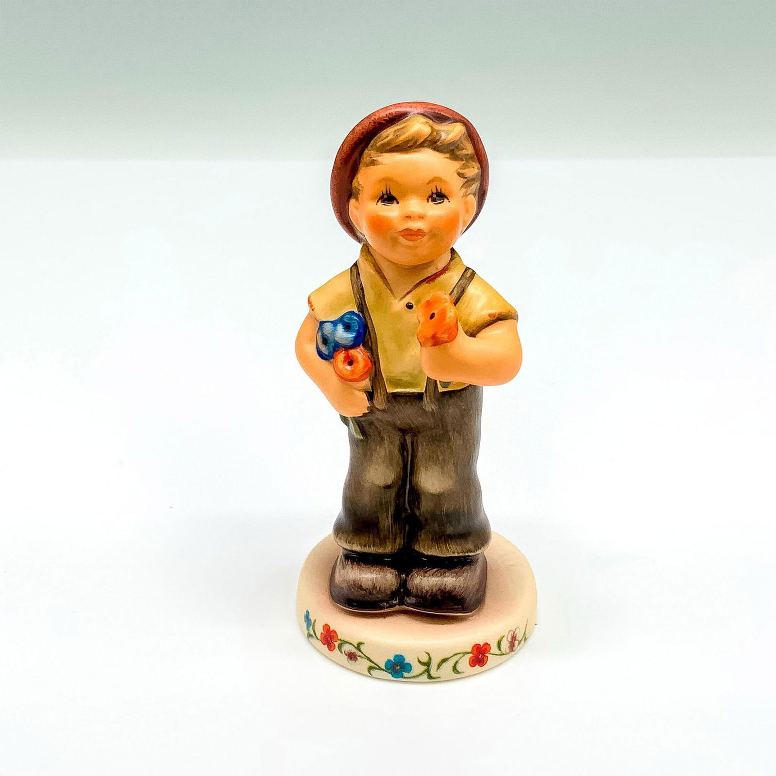 M.I. Hummel Figurine, Pocketful of Posies 2174/B: This special edition figurine depicts a young boy holding flowers. It has the Goebel backstamp on the bottom. Item comes with its original box that measures 3"L x 3"W x 4.5"H. Dimensions: 1.75"dia. x