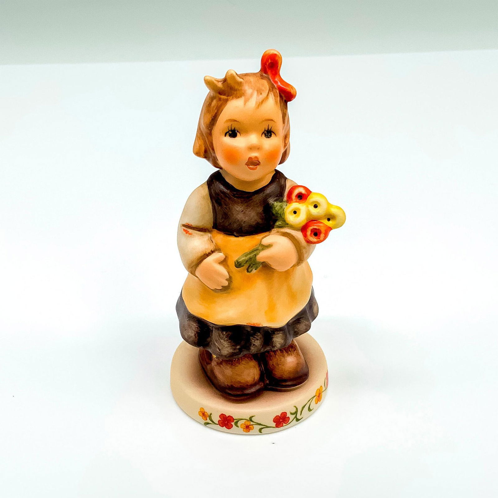 M.I. Hummel Porcelain Figurine, Pretty Posie 2174/A: This special edition figurine depicts a young girl holding flowers. It has the Goebel backstamp on the bottom. Item comes with its original box that measures 3"L x 3"W x 4.5"H. Dimensions: 1.75"dia. x